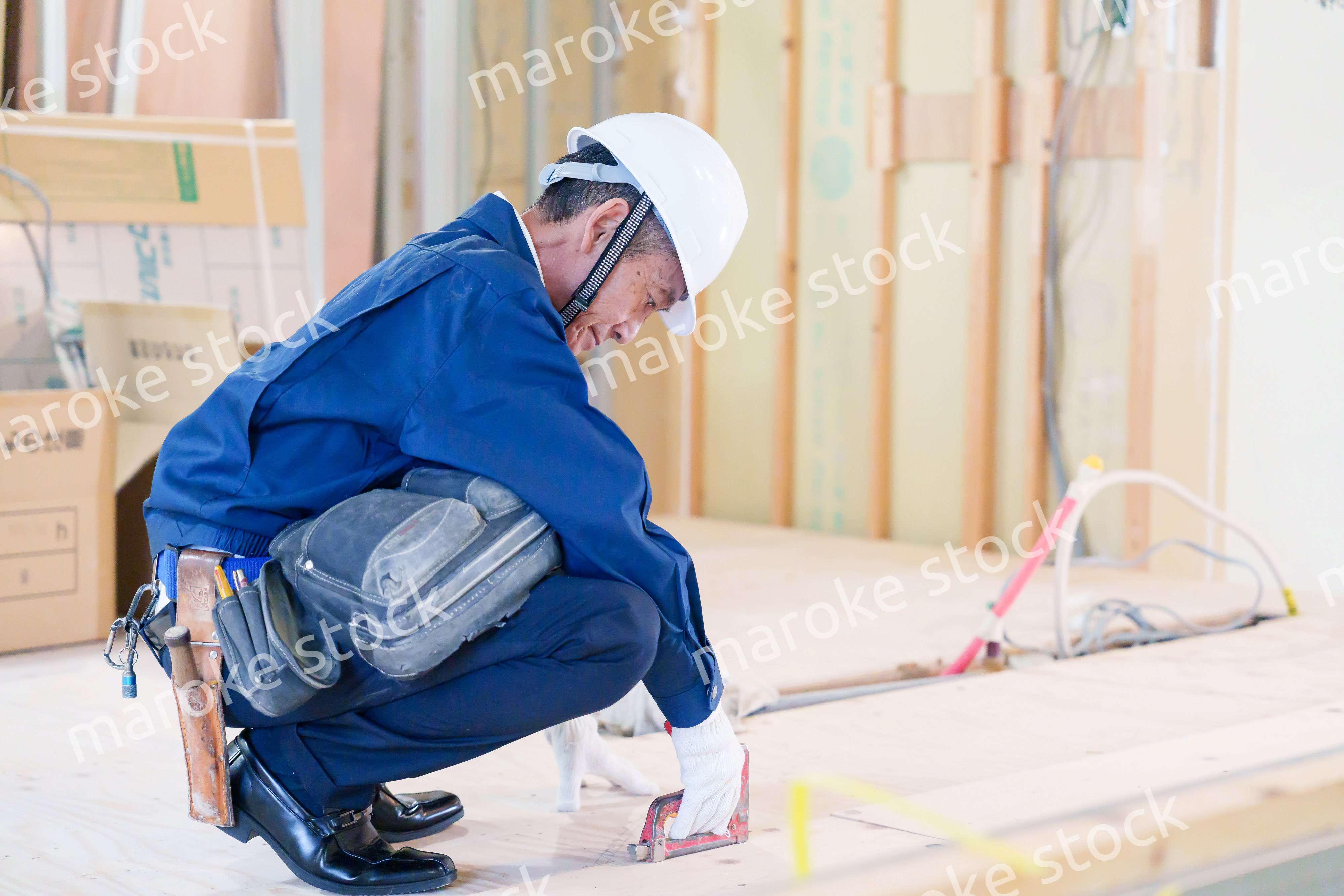 タッカーで建築資材を固定する男性の職人