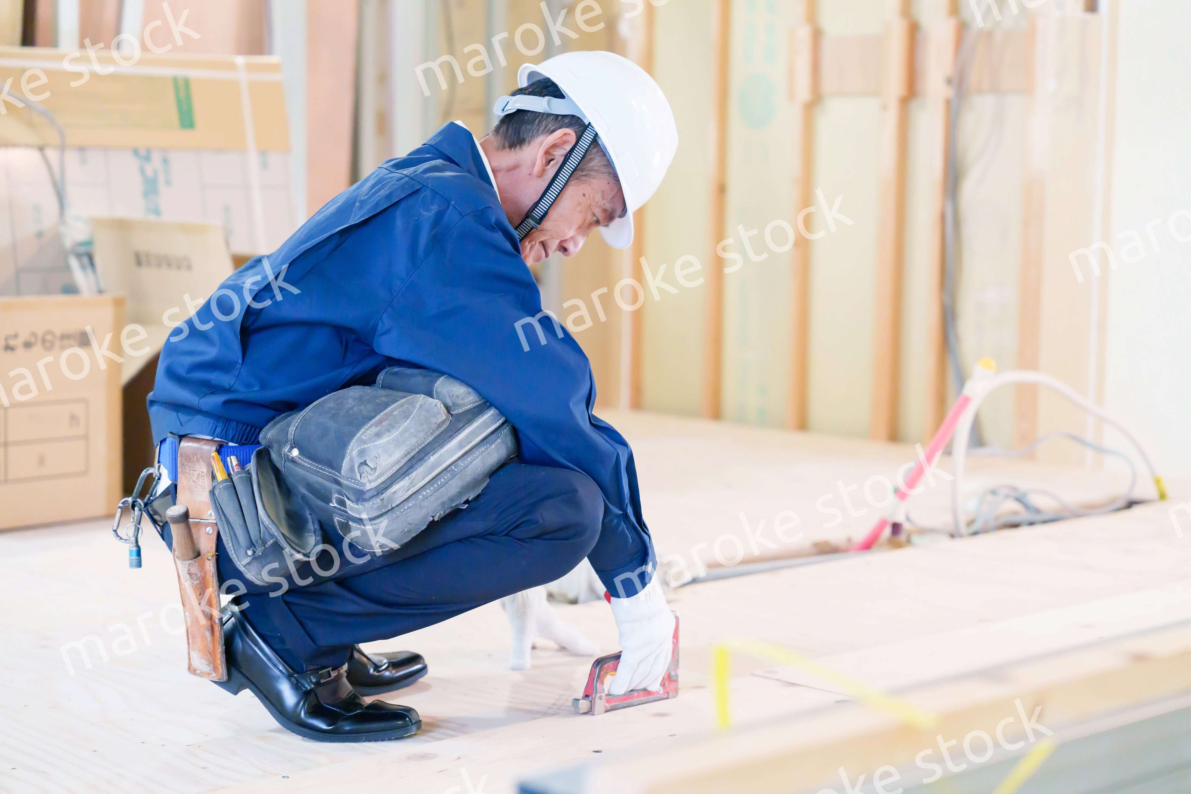 タッカーで建築資材を固定する男性の職人