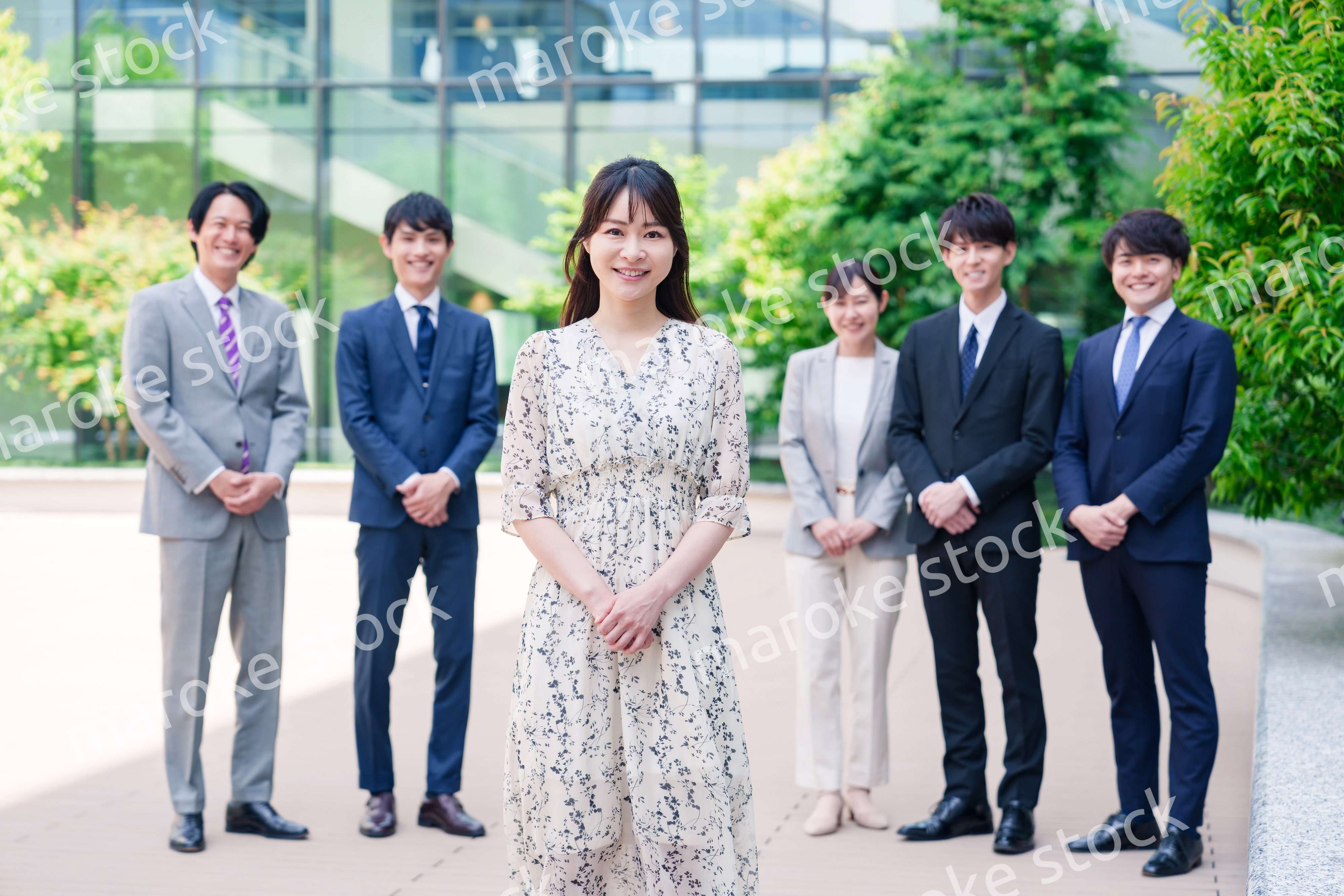 オフィス街に立つ若い女性キャリアウーマンとスタッフ