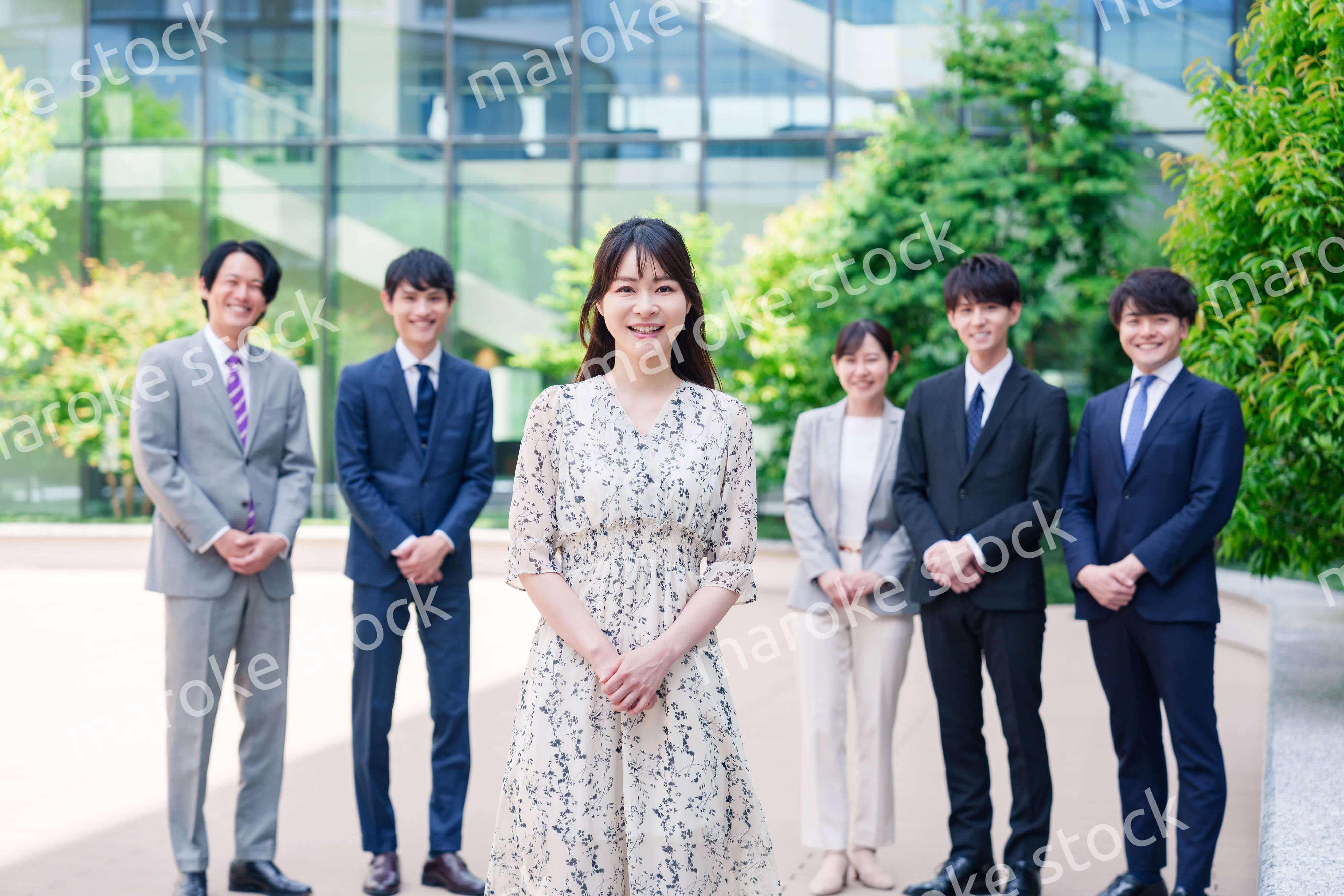 オフィス街に立つ若い女性キャリアウーマンとスタッフ