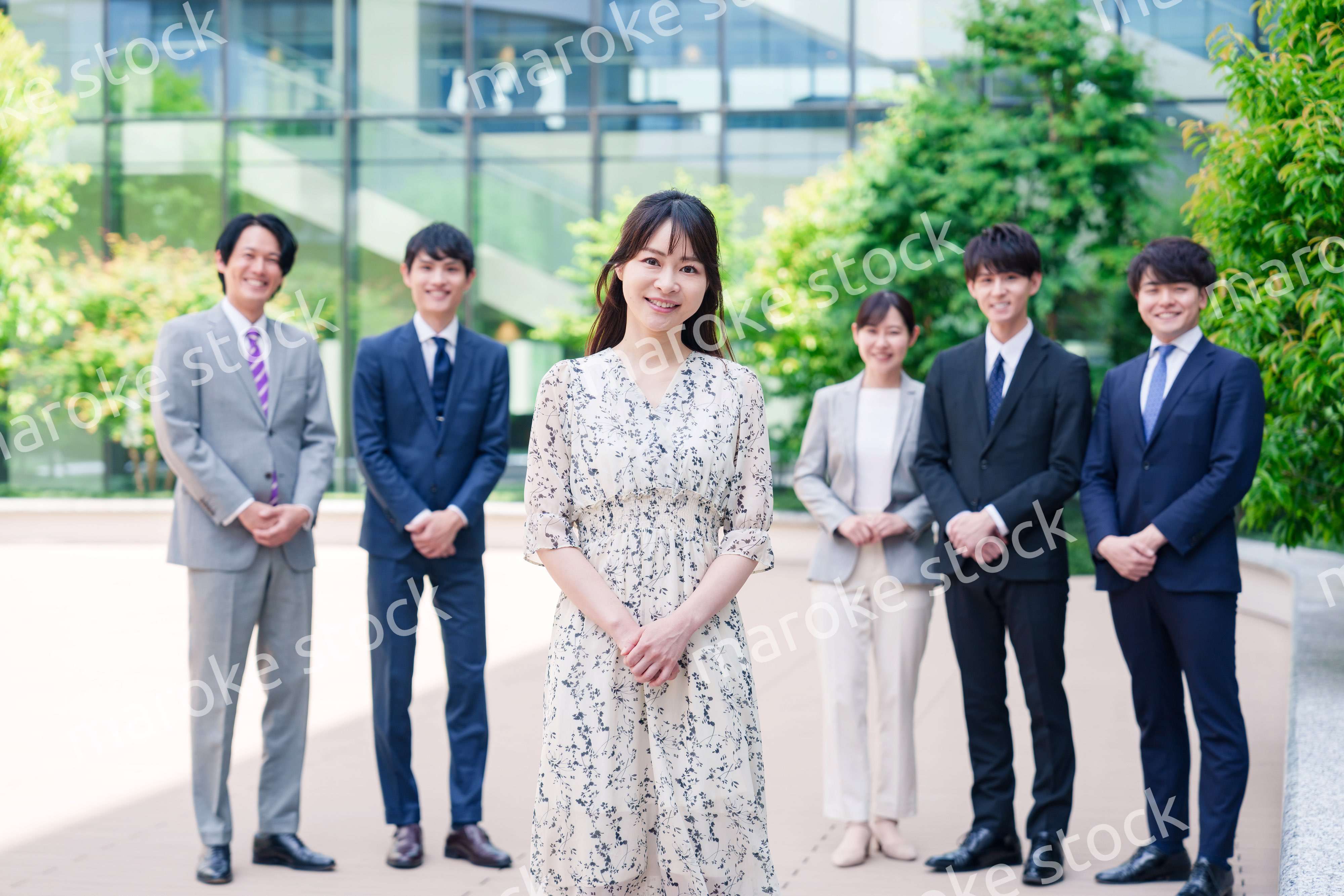 オフィス街に立つ若い女性キャリアウーマンとスタッフ