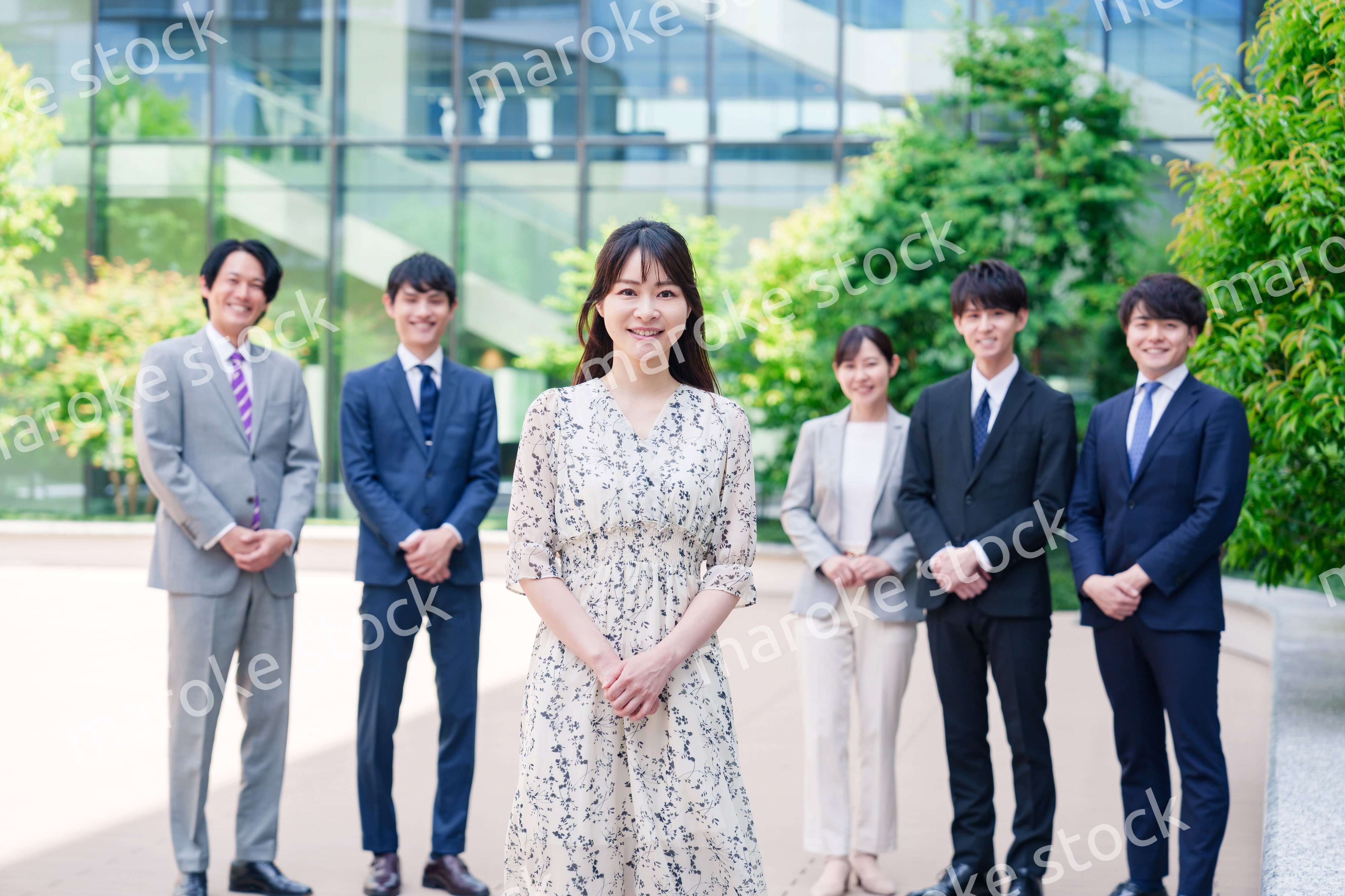 オフィス街に立つ若い女性キャリアウーマンとスタッフ