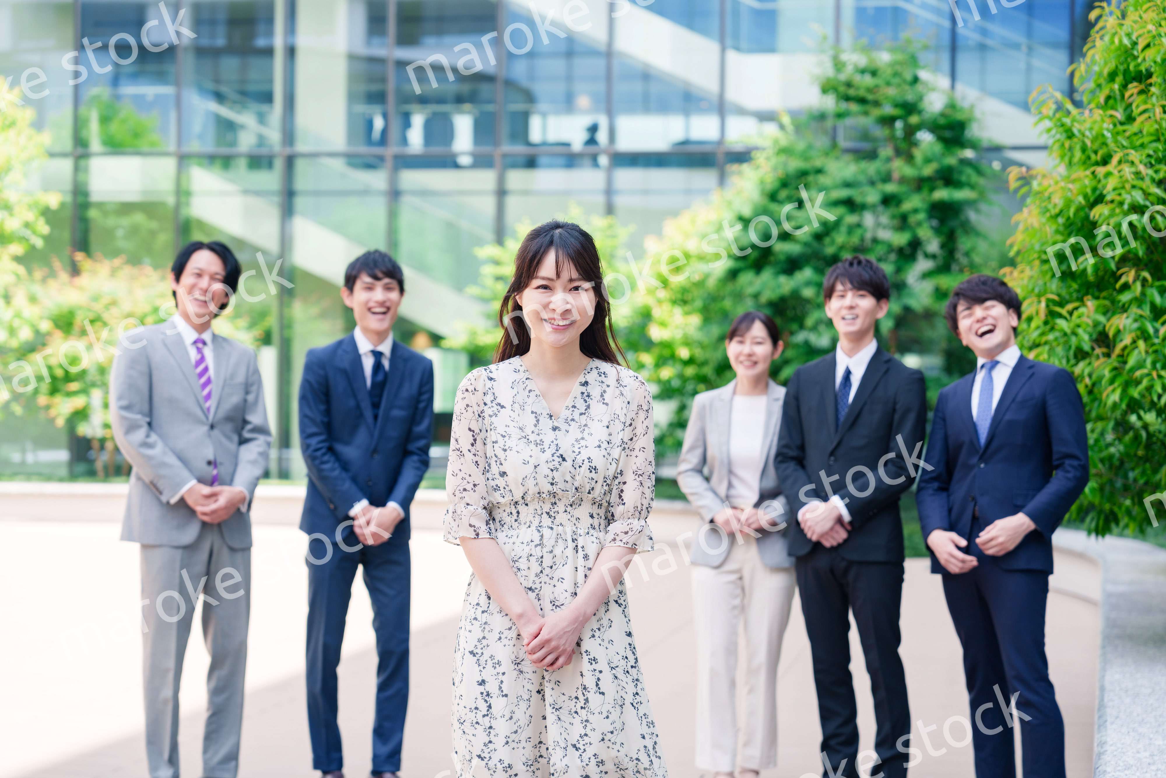 オフィス街に立つ若い女性キャリアウーマンとスタッフ