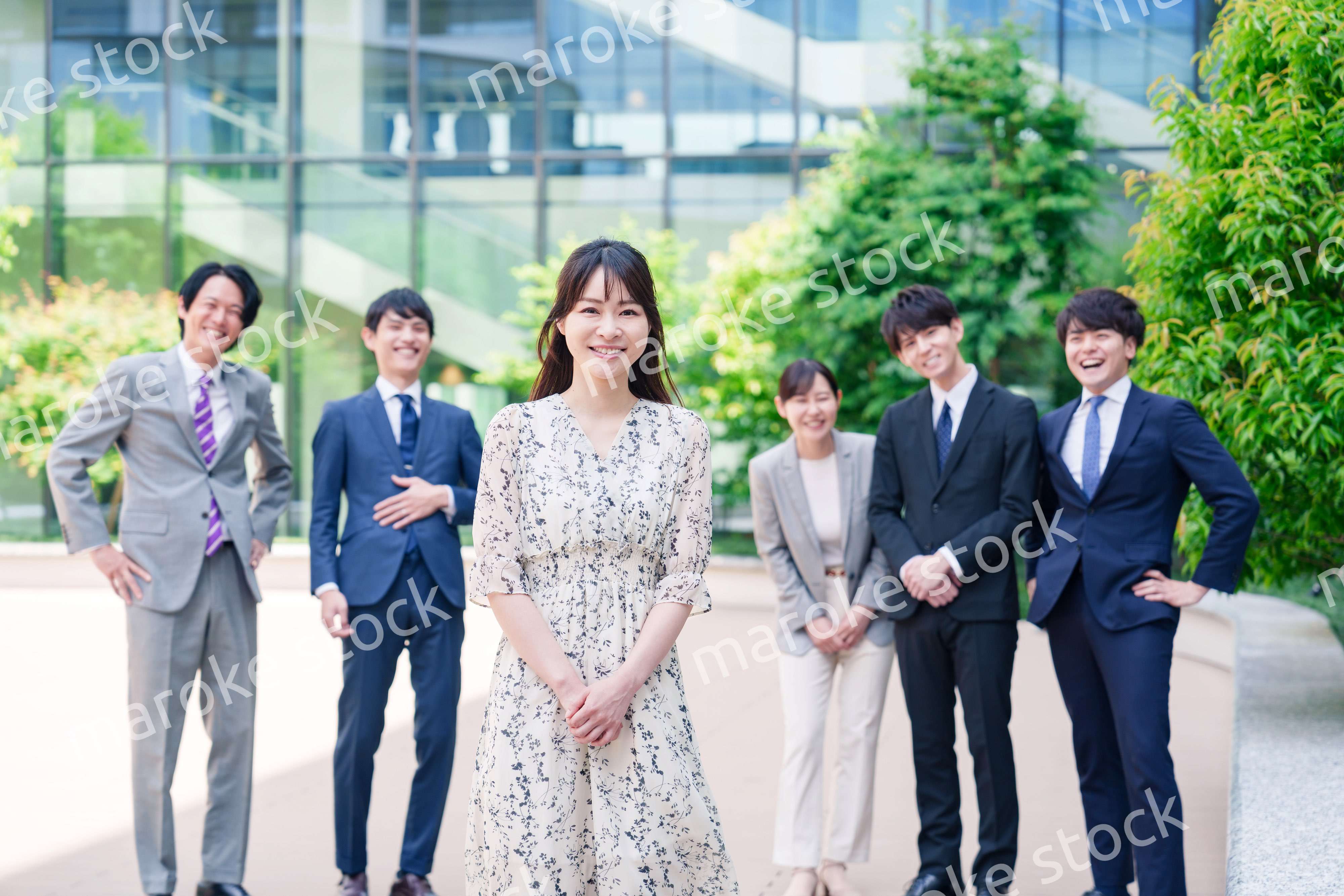 オフィス街に立つ若い女性キャリアウーマンとスタッフ