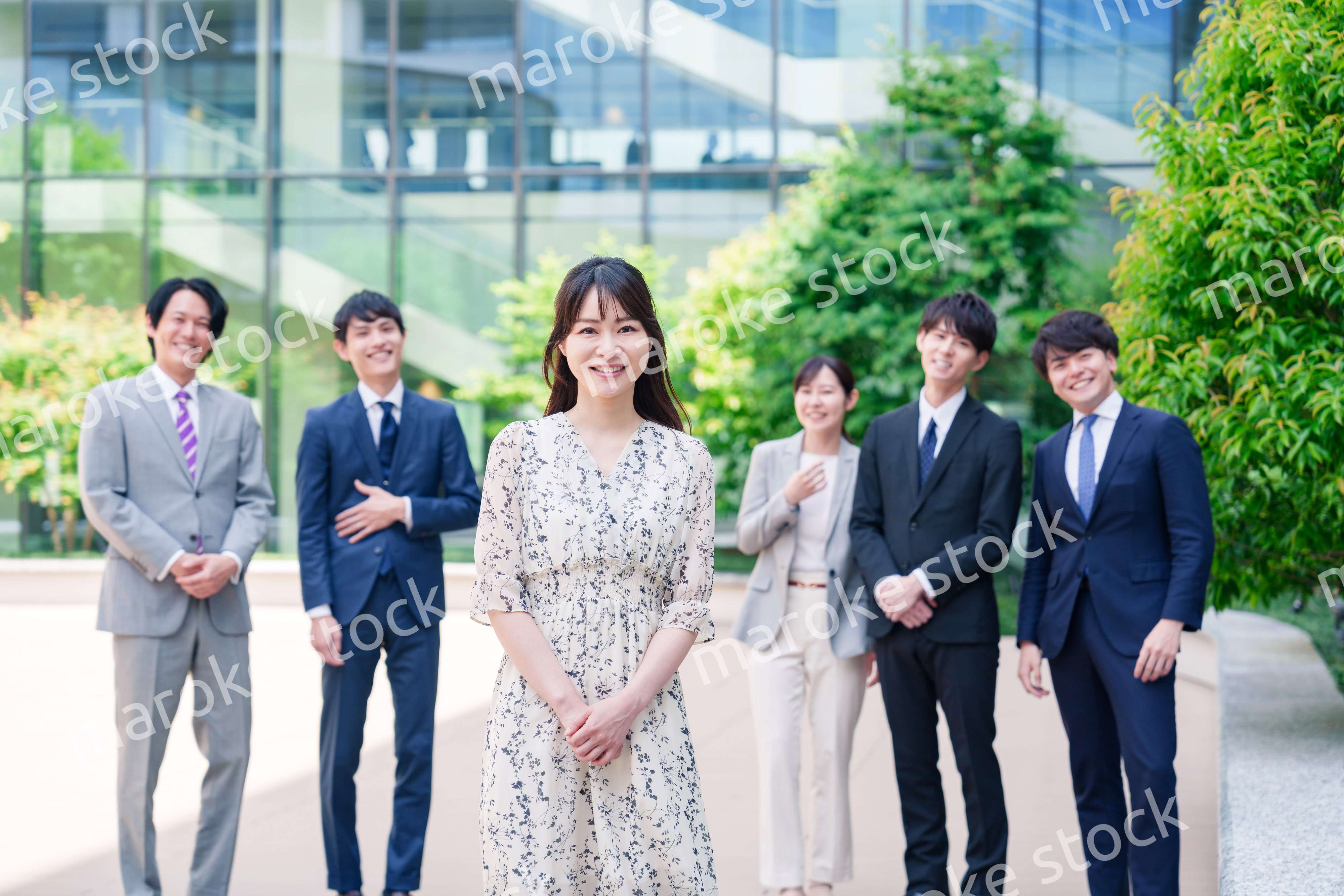 オフィス街に立つ若い女性キャリアウーマンとスタッフ