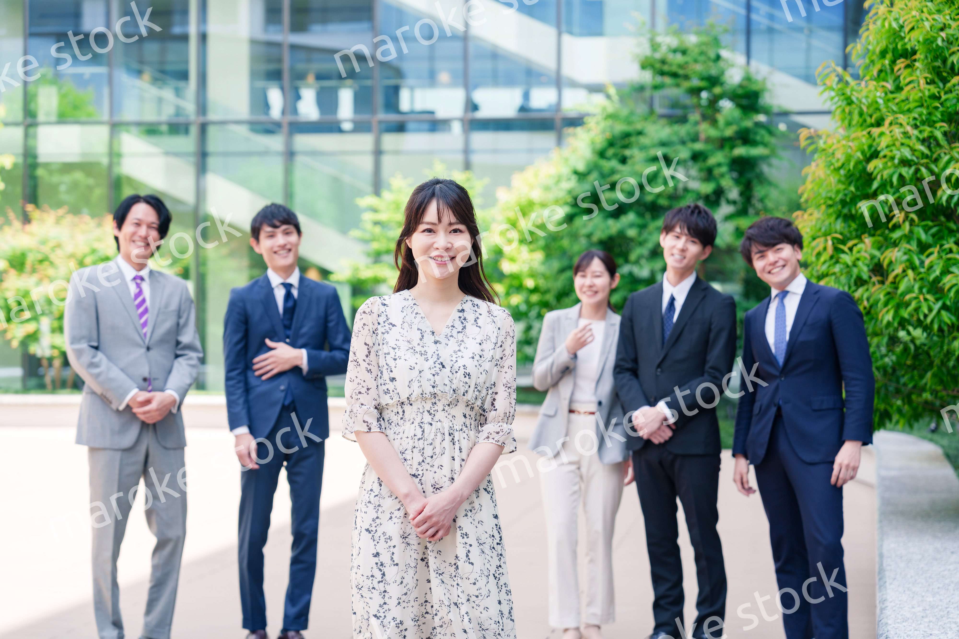 オフィス街に立つ若い女性キャリアウーマンとスタッフ