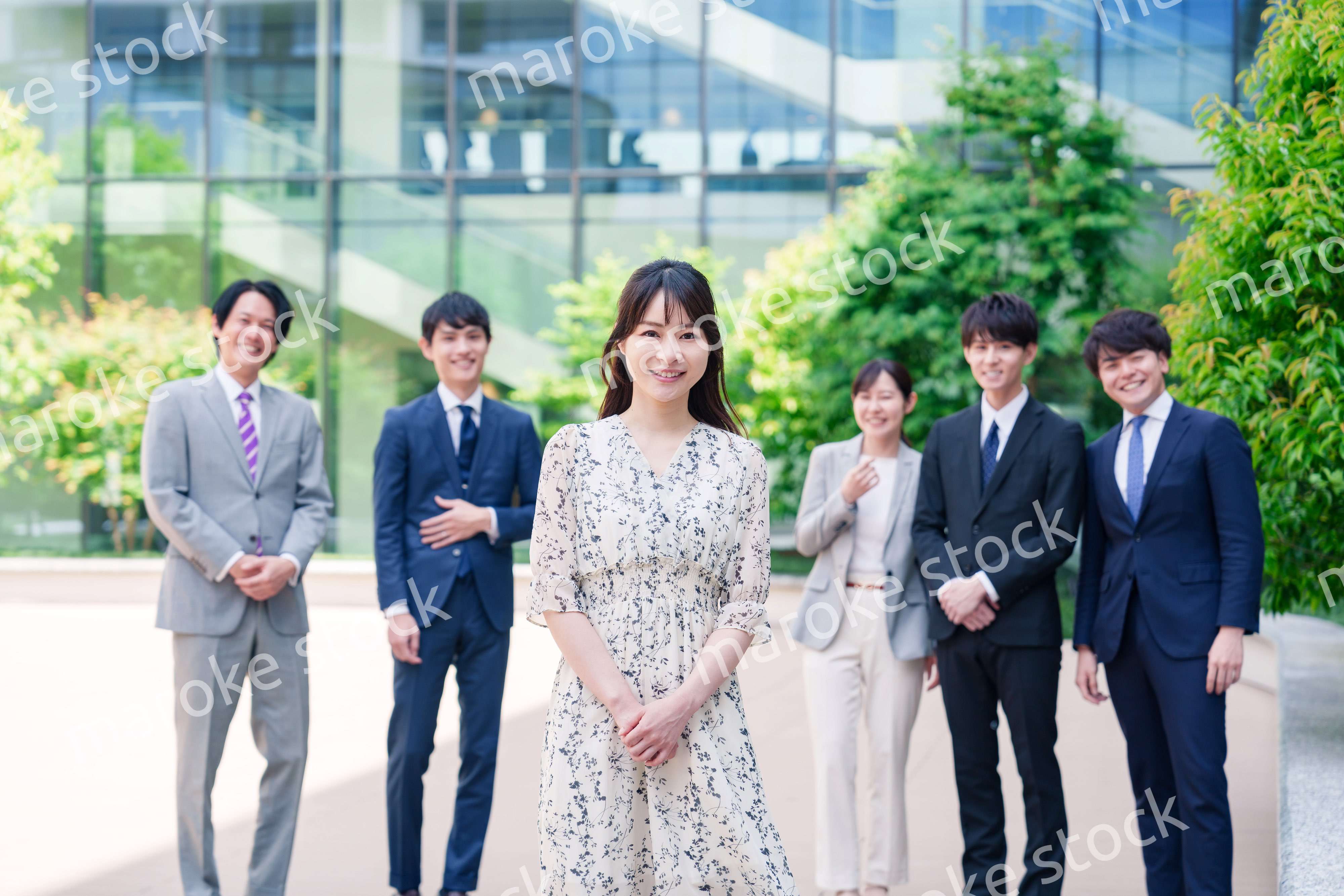 オフィス街に立つ若い女性キャリアウーマンとスタッフ