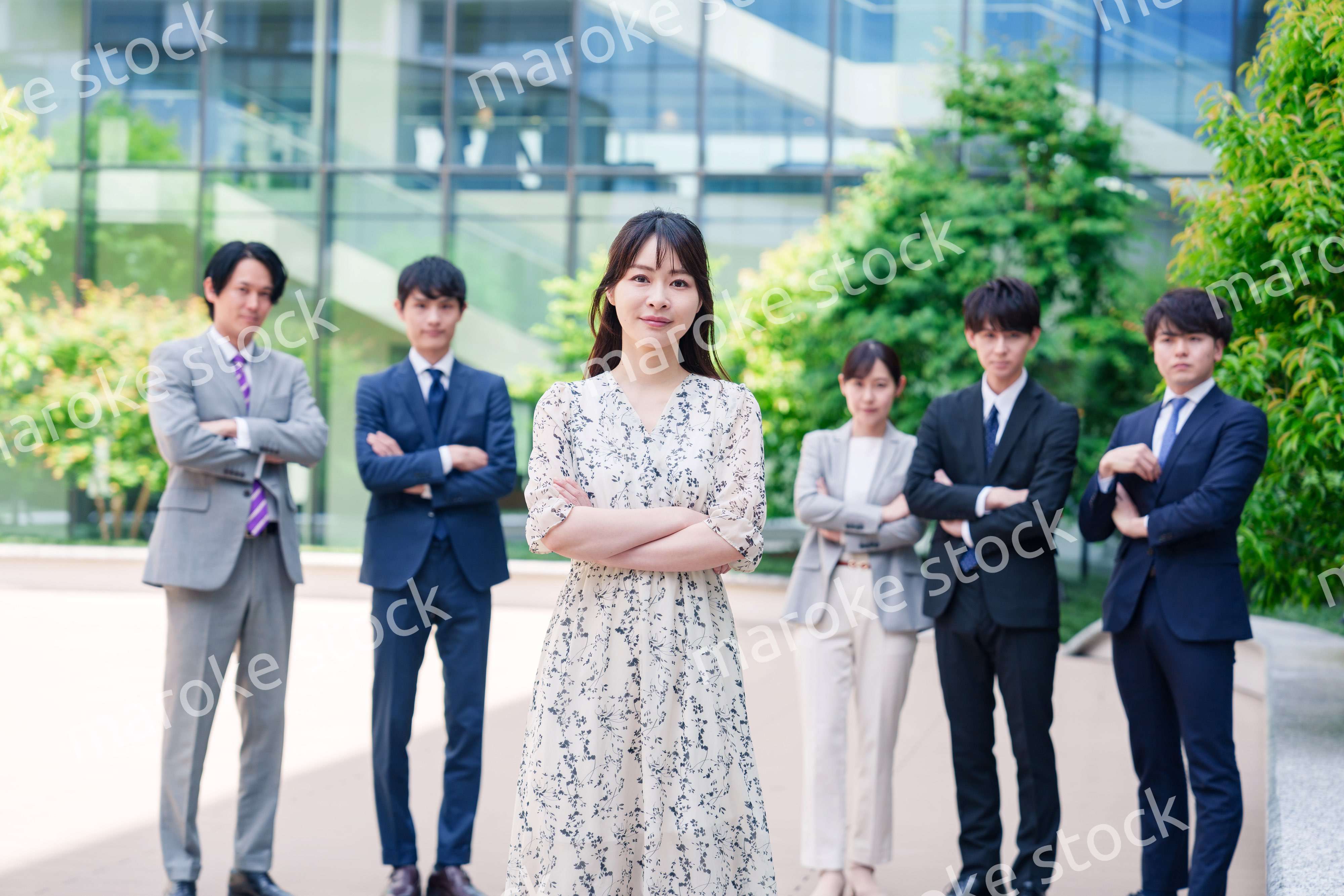 オフィス街に立つ若い女性キャリアウーマンとスタッフ