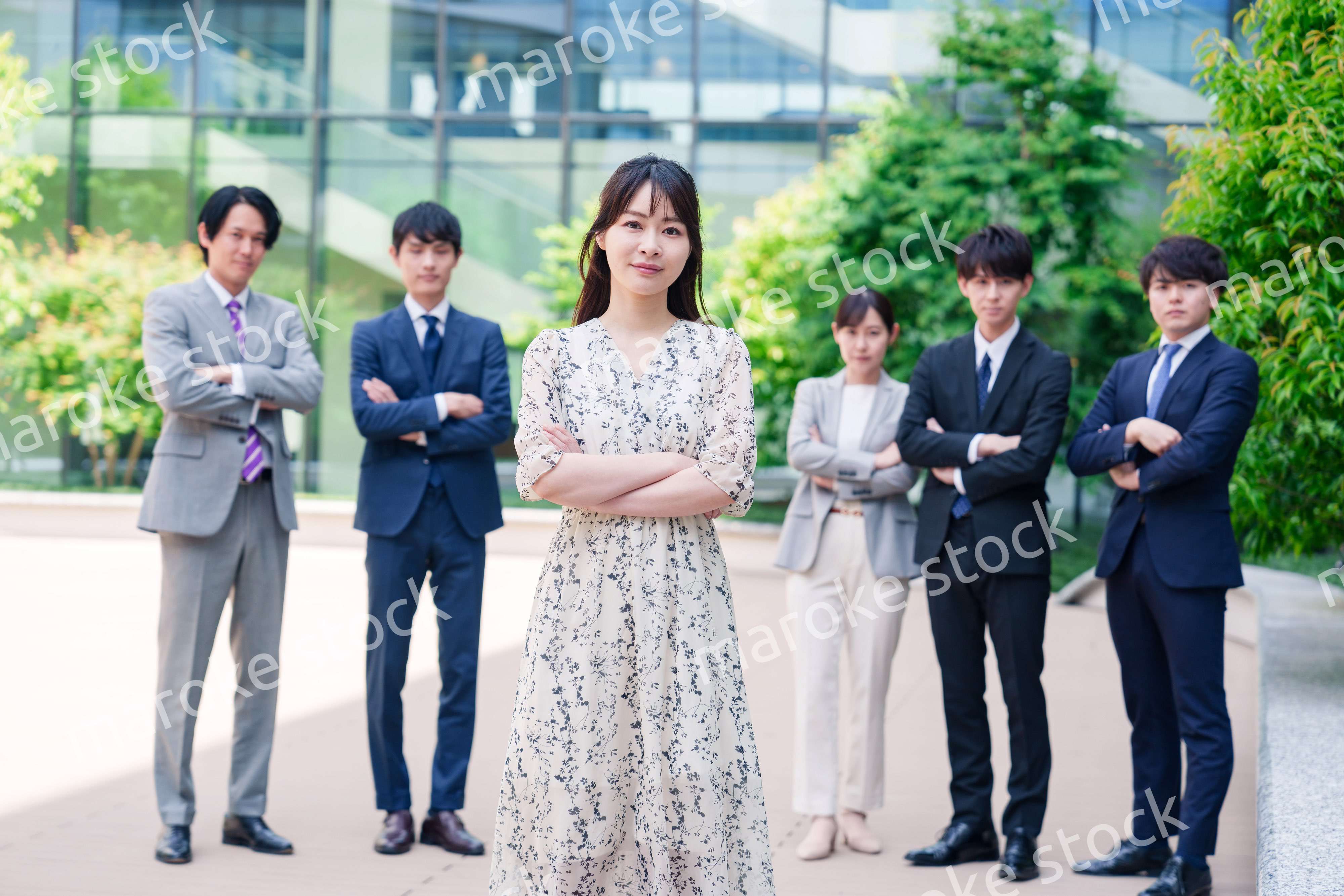 オフィス街に立つ若い女性キャリアウーマンとスタッフ