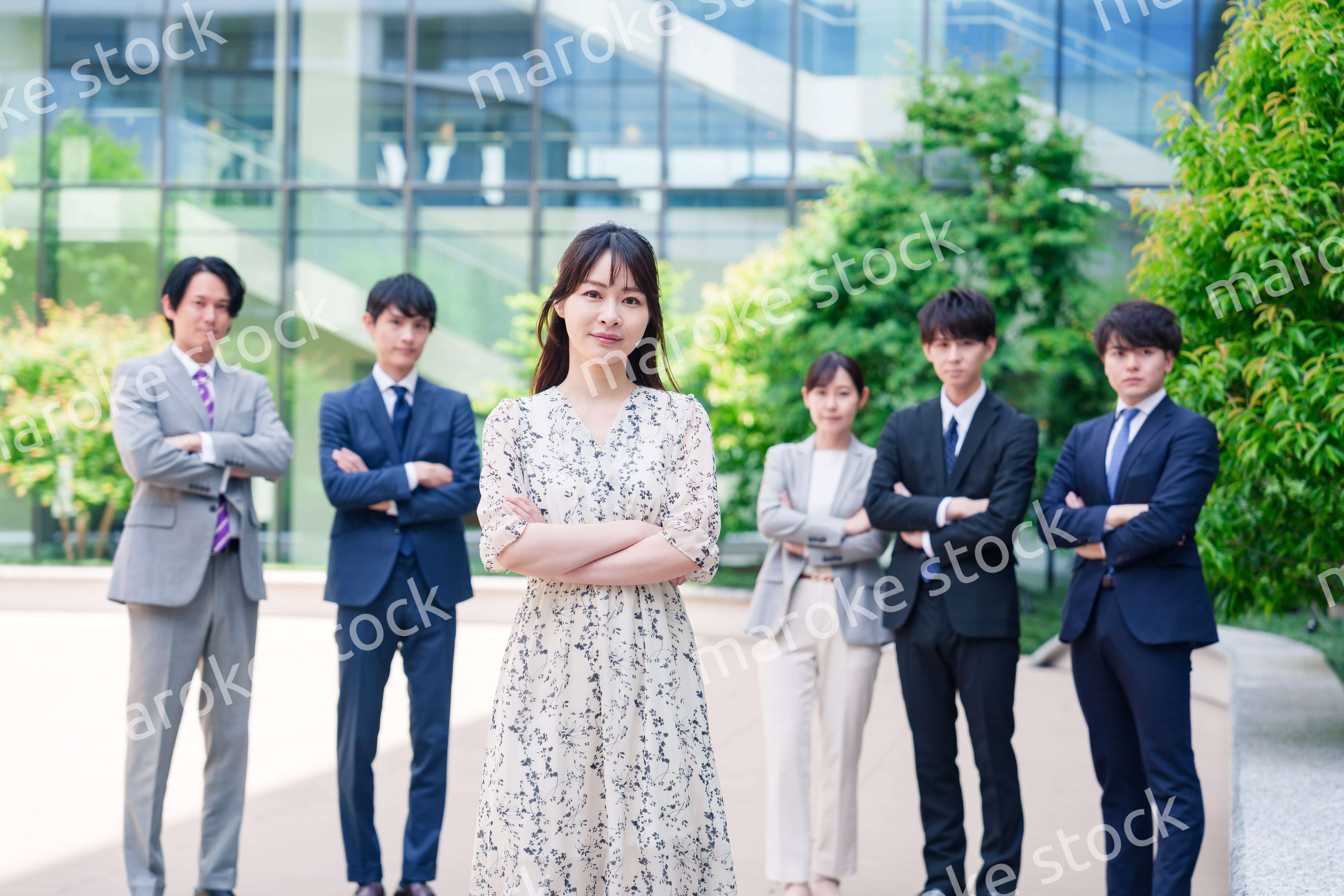 オフィス街に立つ若い女性キャリアウーマンとスタッフ