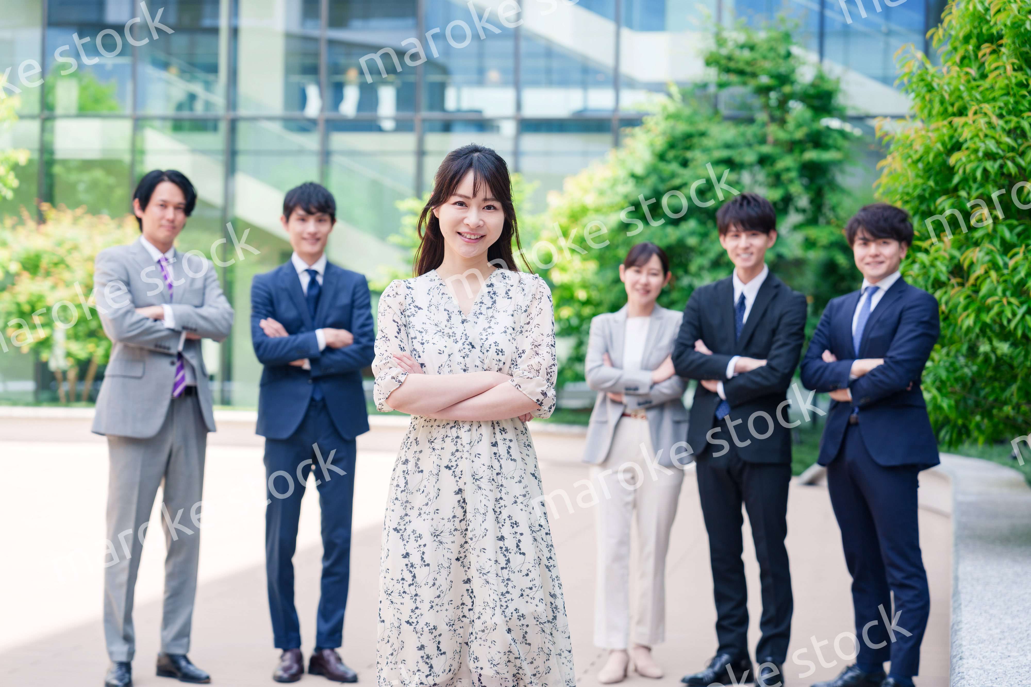 オフィス街に立つ若い女性キャリアウーマンとスタッフ