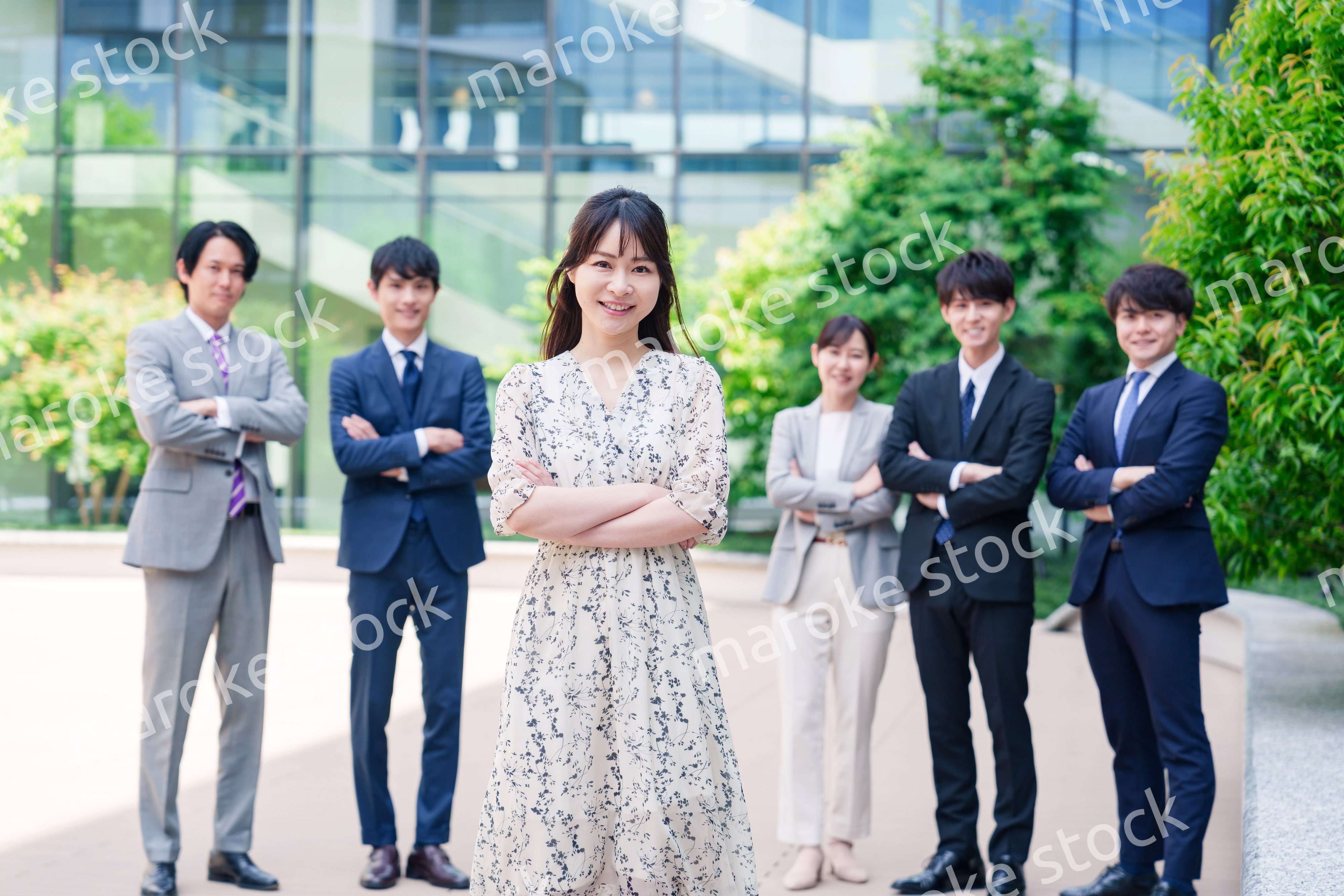 オフィス街に立つ若い女性キャリアウーマンとスタッフ