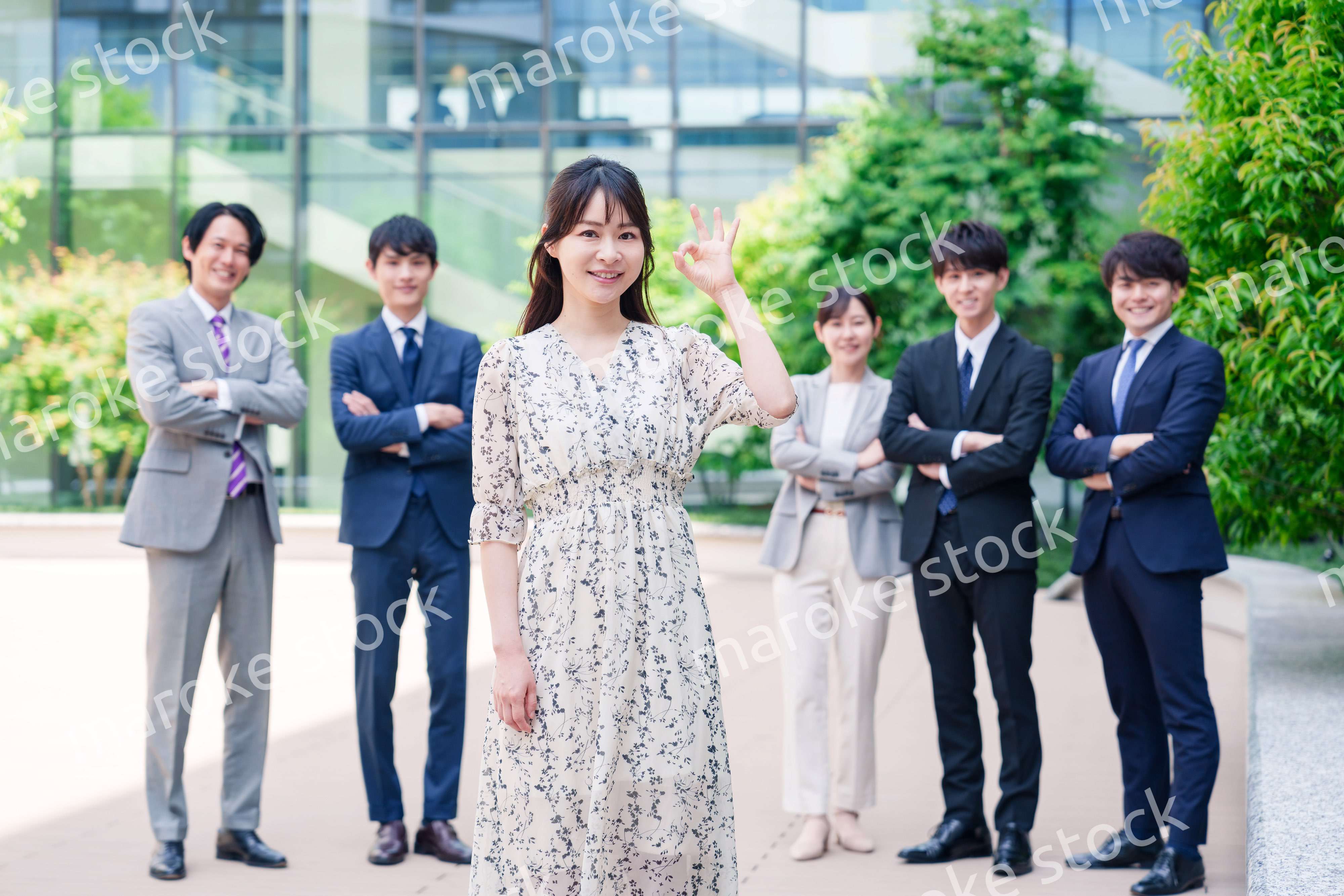 オフィス街に立つ若い女性キャリアウーマンとスタッフ