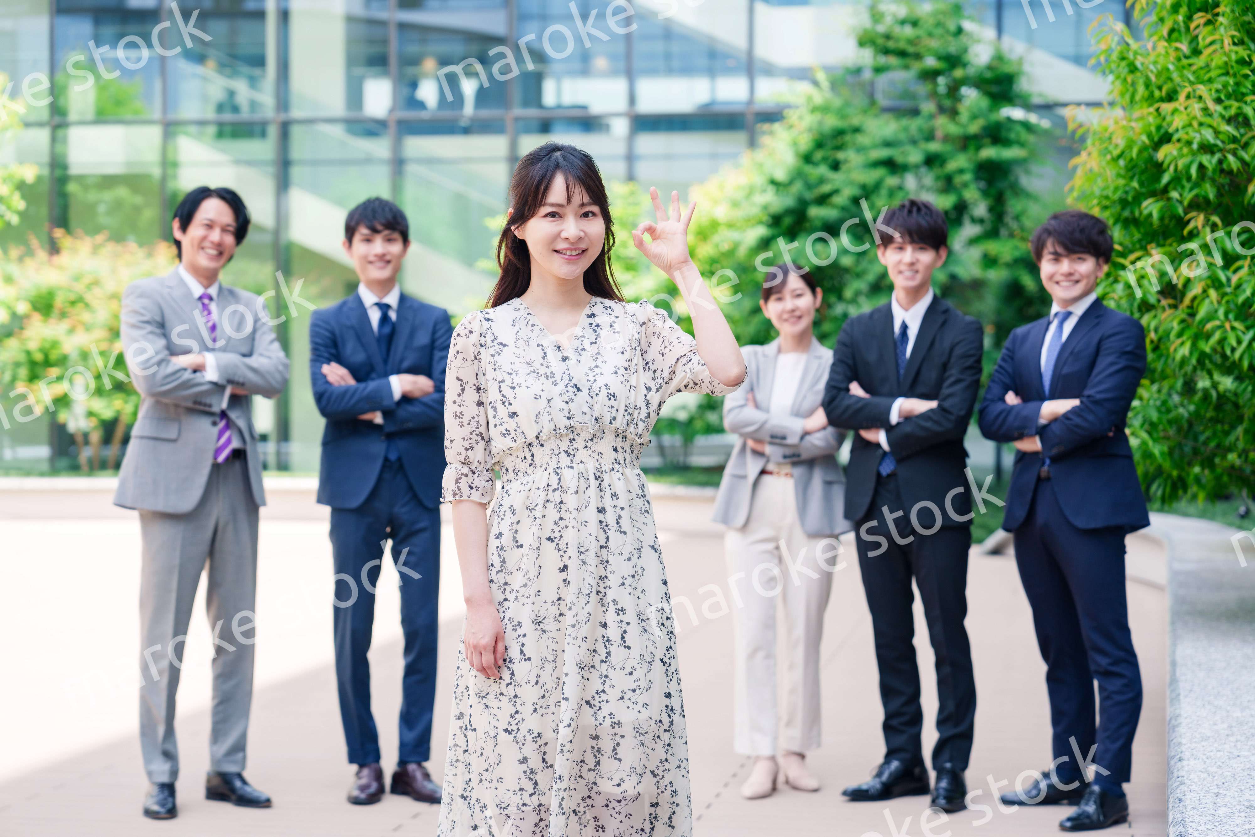 オフィス街に立つ若い女性キャリアウーマンとスタッフ