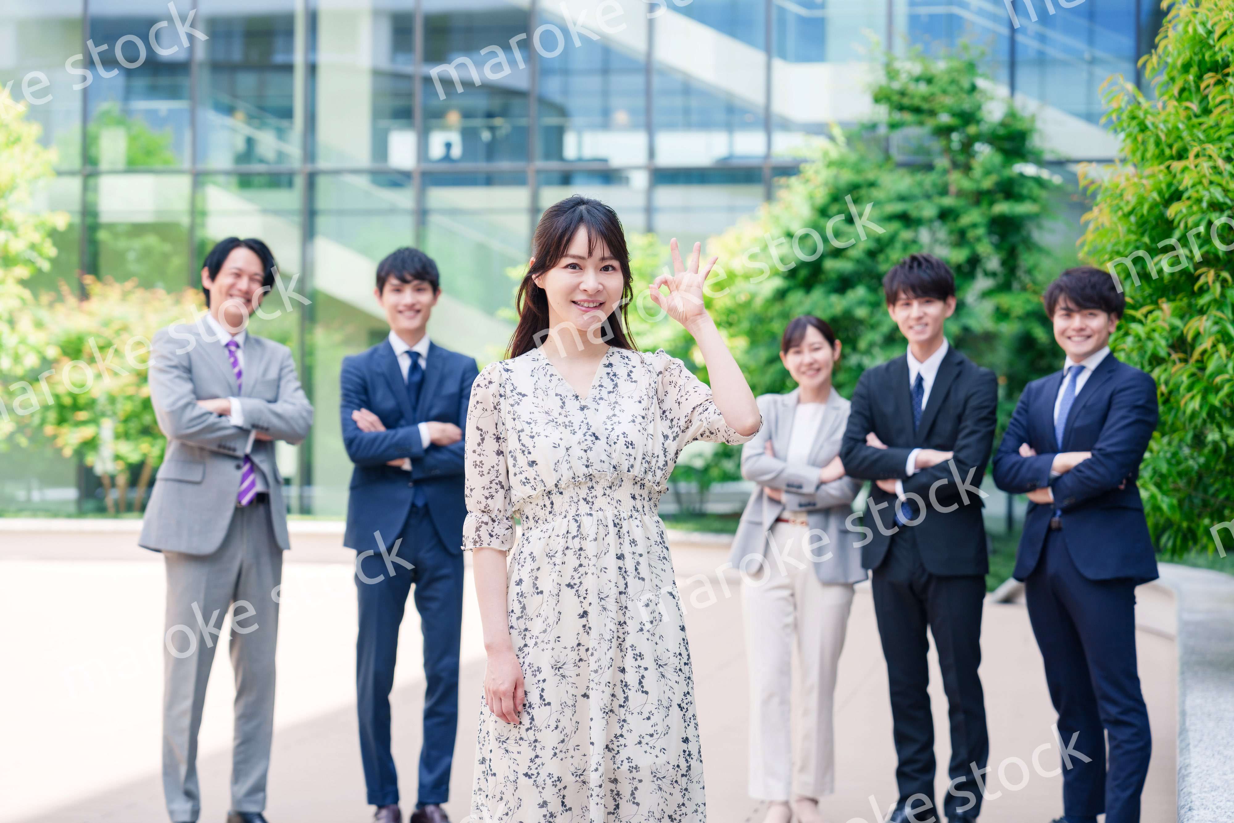 オフィス街に立つ若い女性キャリアウーマンとスタッフ