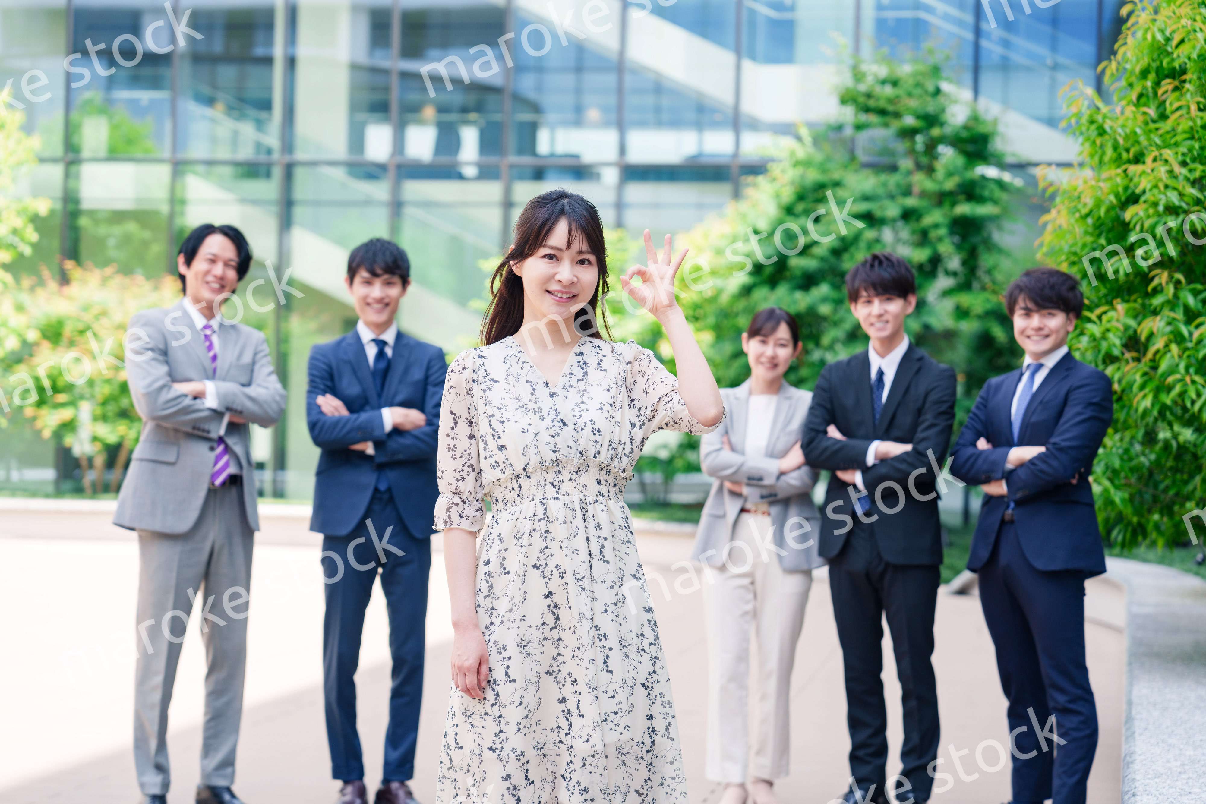 オフィス街に立つ若い女性キャリアウーマンとスタッフ
