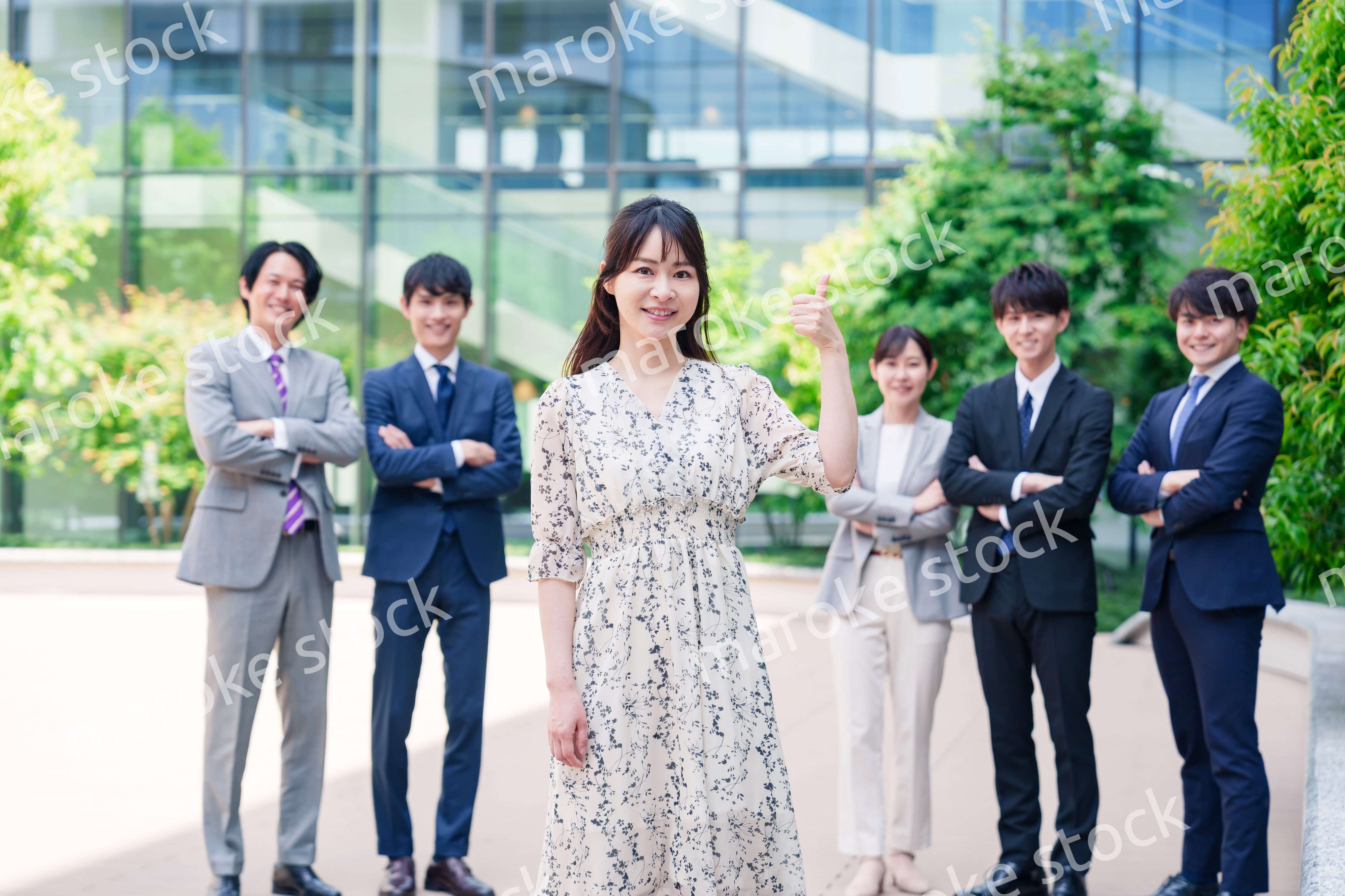 オフィス街に立つ若い女性キャリアウーマンとスタッフ