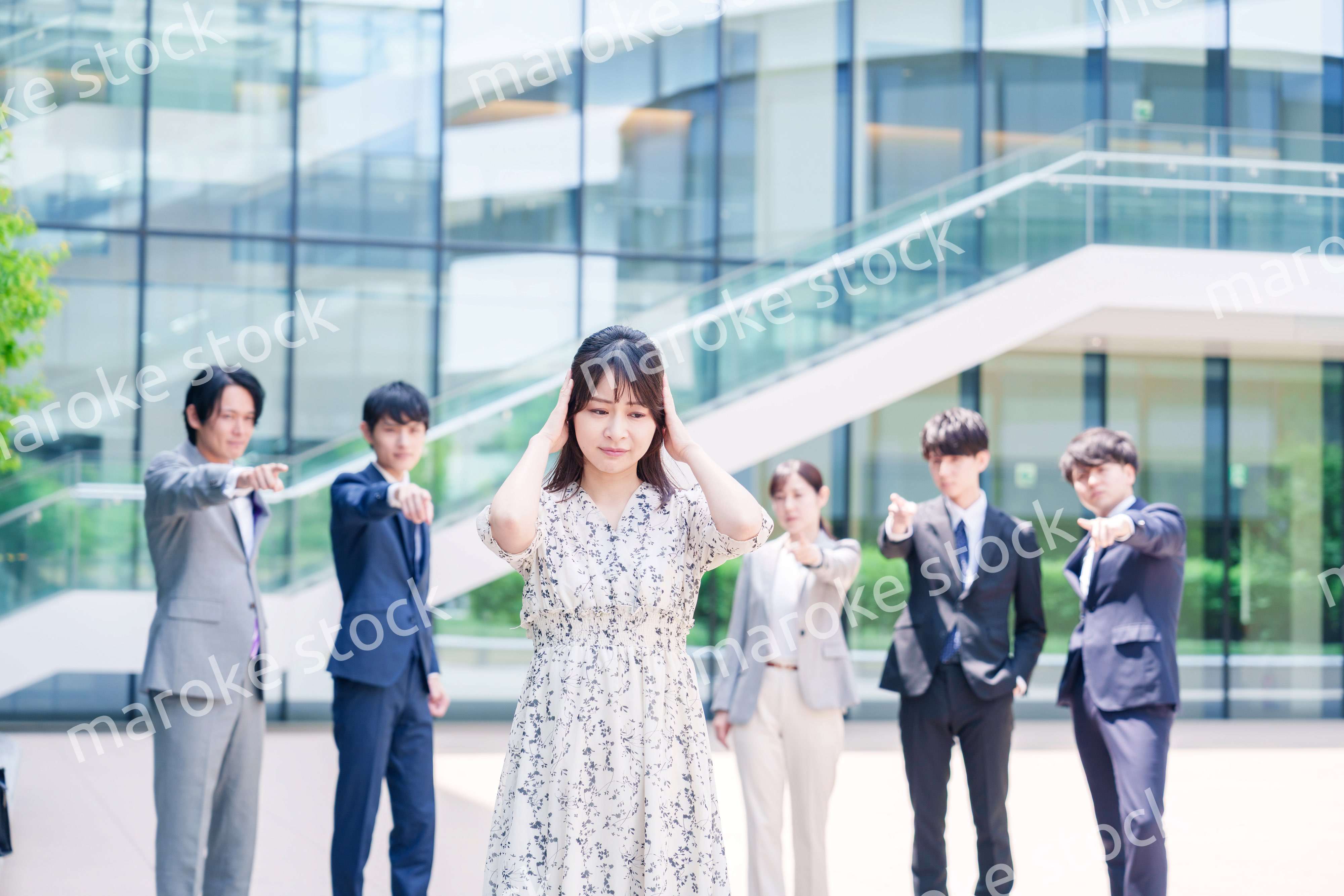 同僚に責められて頭を抱える女性のビジネスパーソン