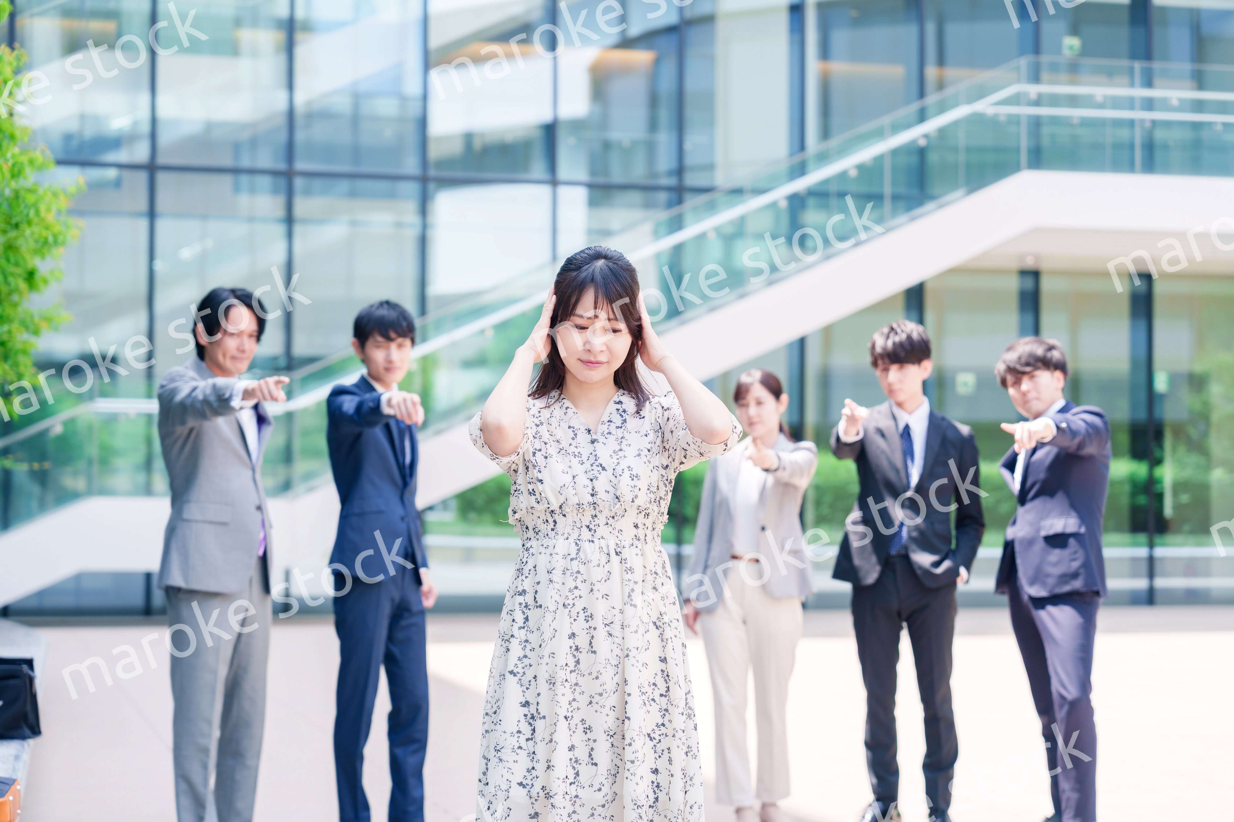 同僚に責められて頭を抱える女性のビジネスパーソン