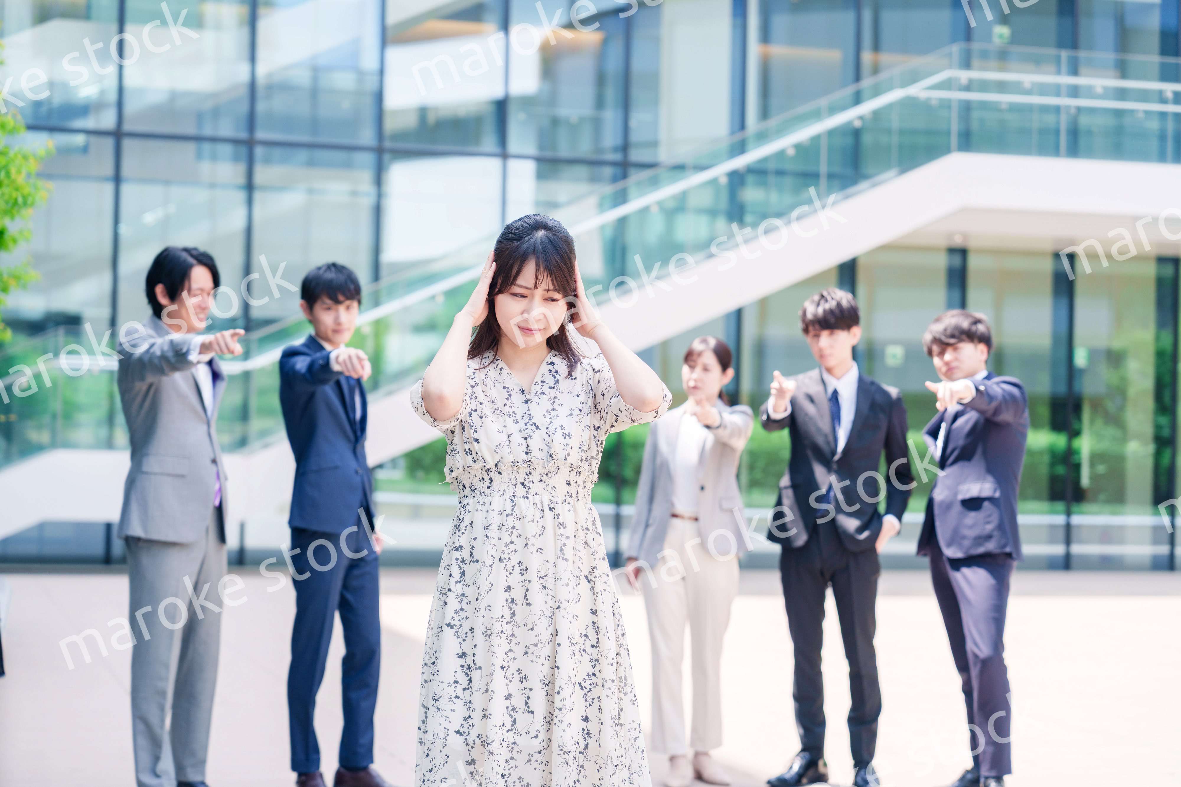 同僚に責められて頭を抱える女性のビジネスパーソン