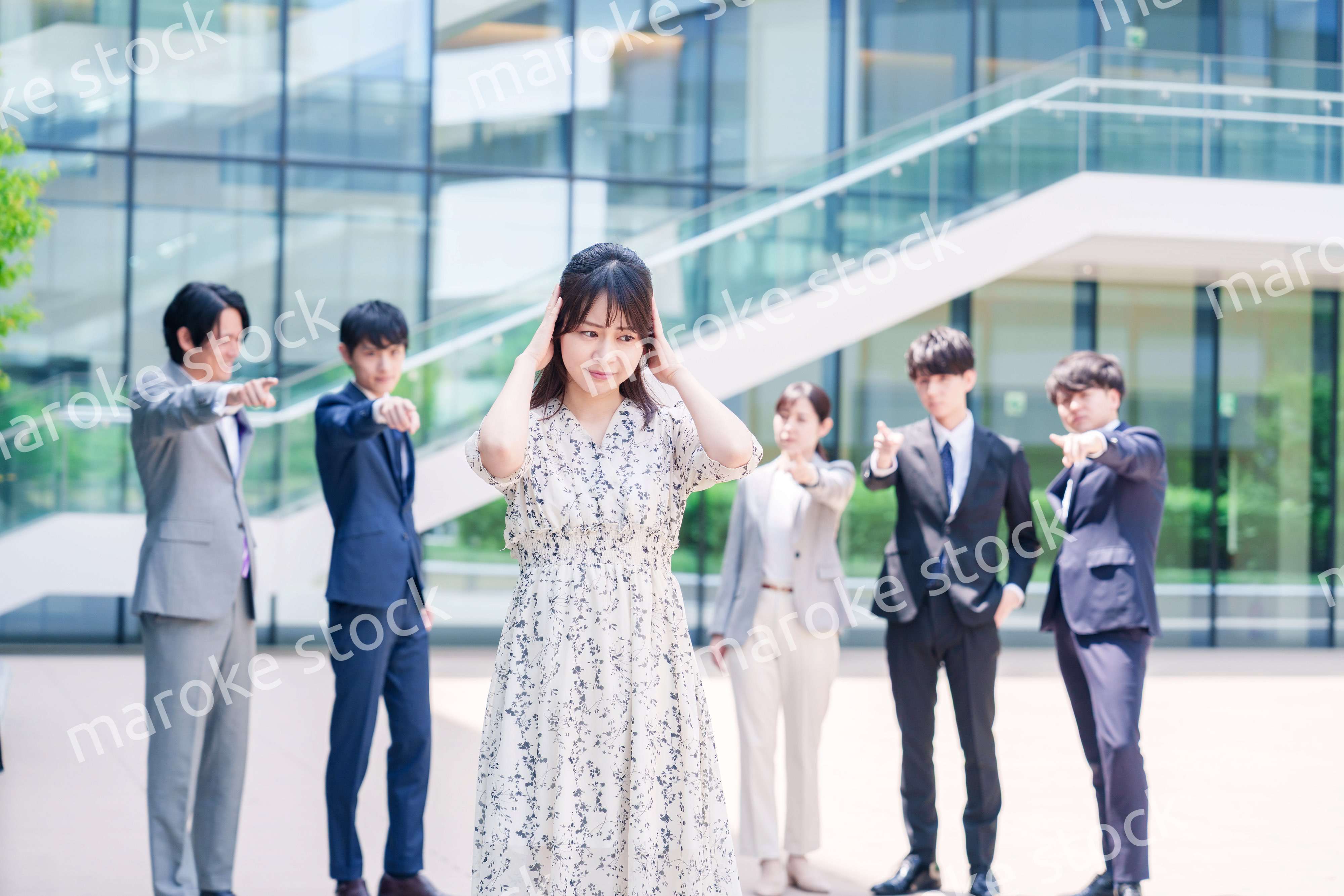 同僚に責められて頭を抱える女性のビジネスパーソン