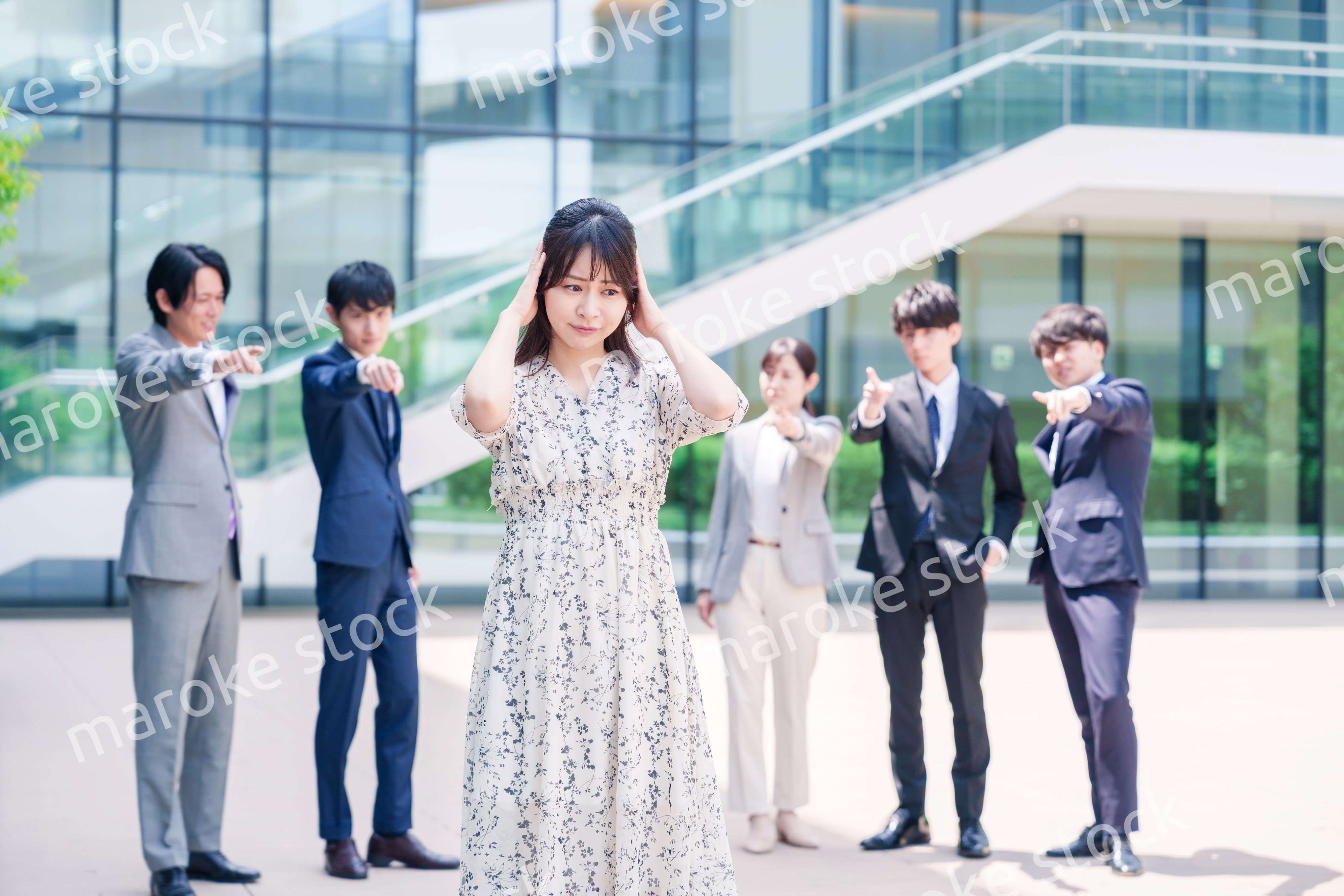 同僚に責められて頭を抱える女性のビジネスパーソン