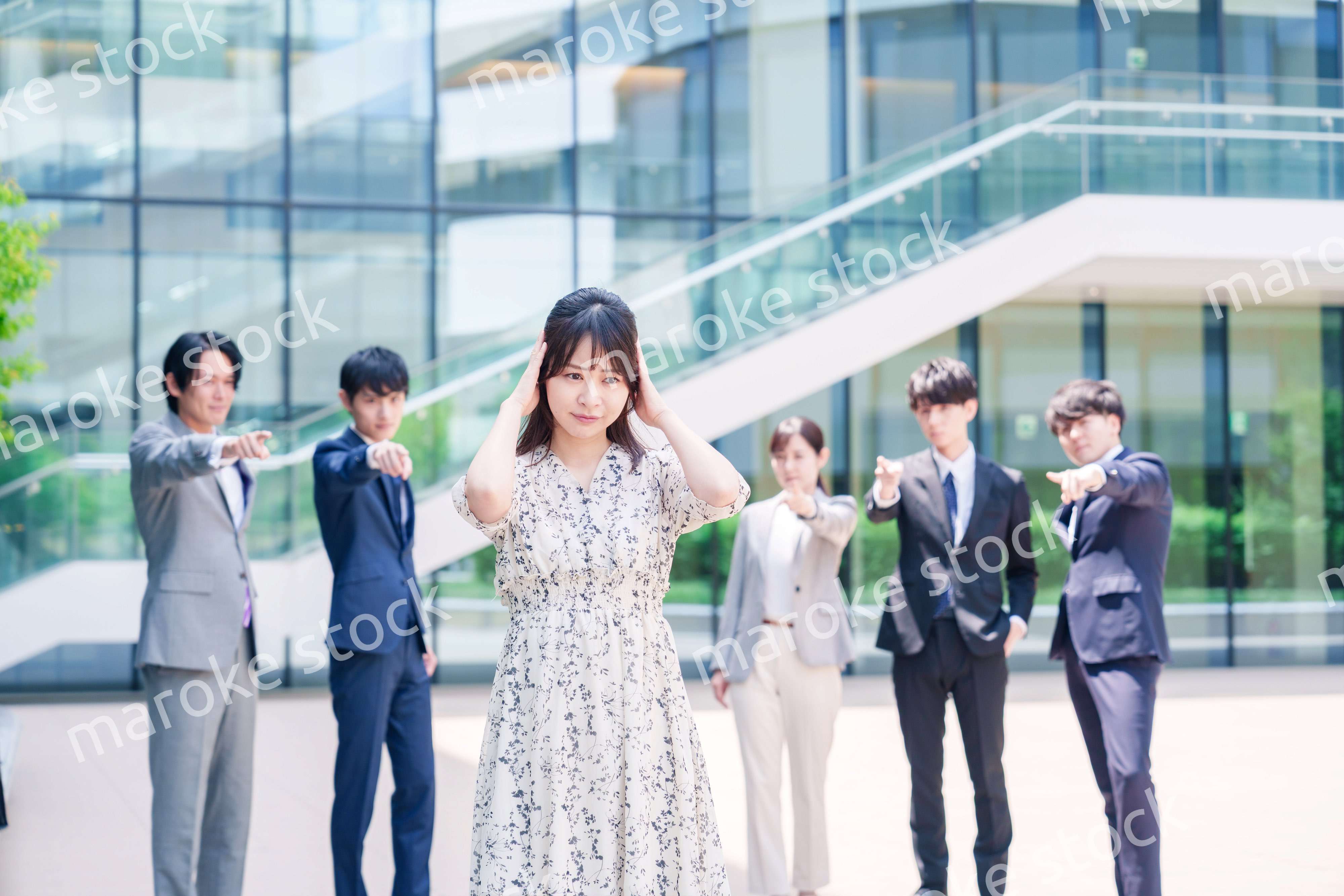 同僚に責められて頭を抱える女性のビジネスパーソン