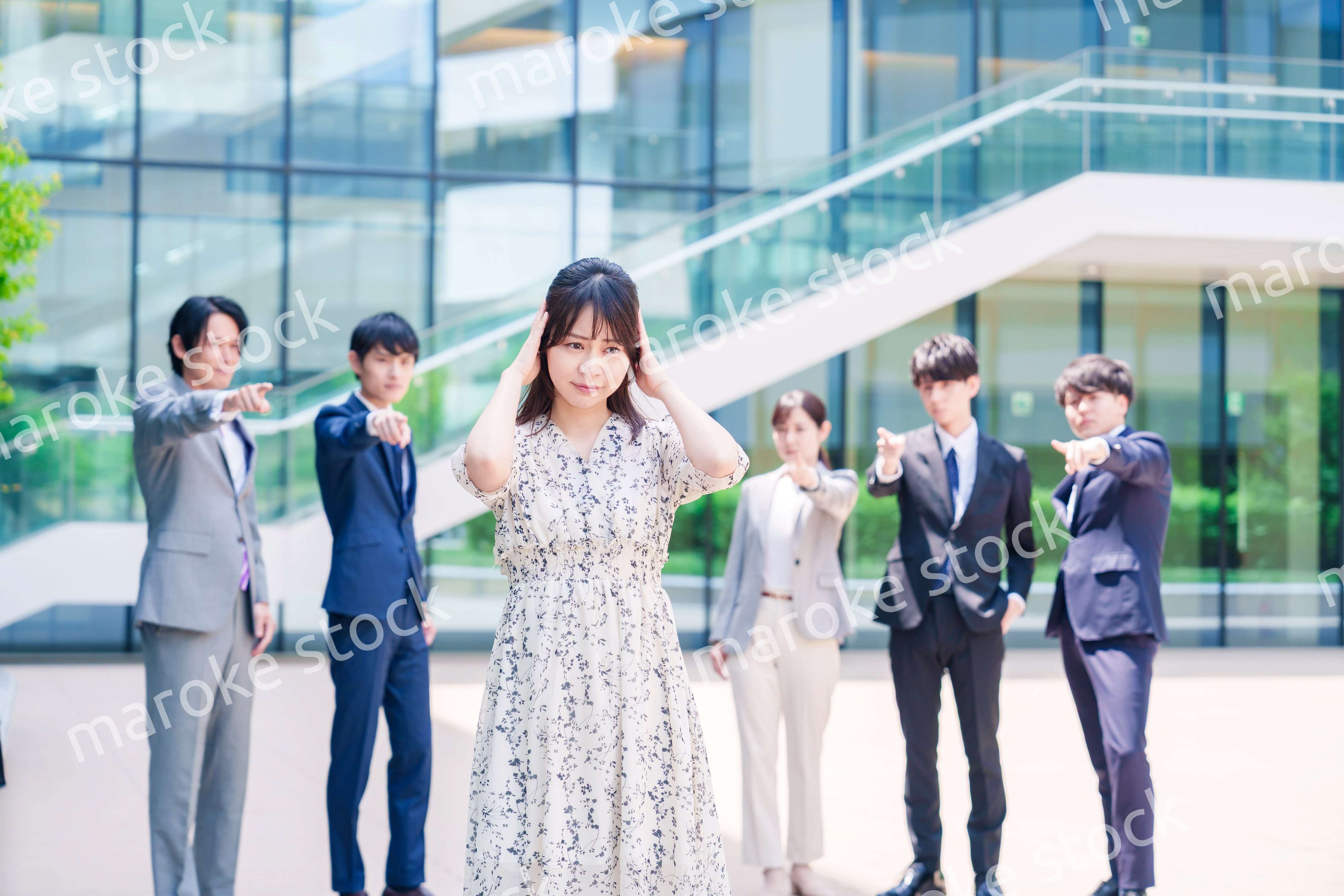 同僚に責められて頭を抱える女性のビジネスパーソン