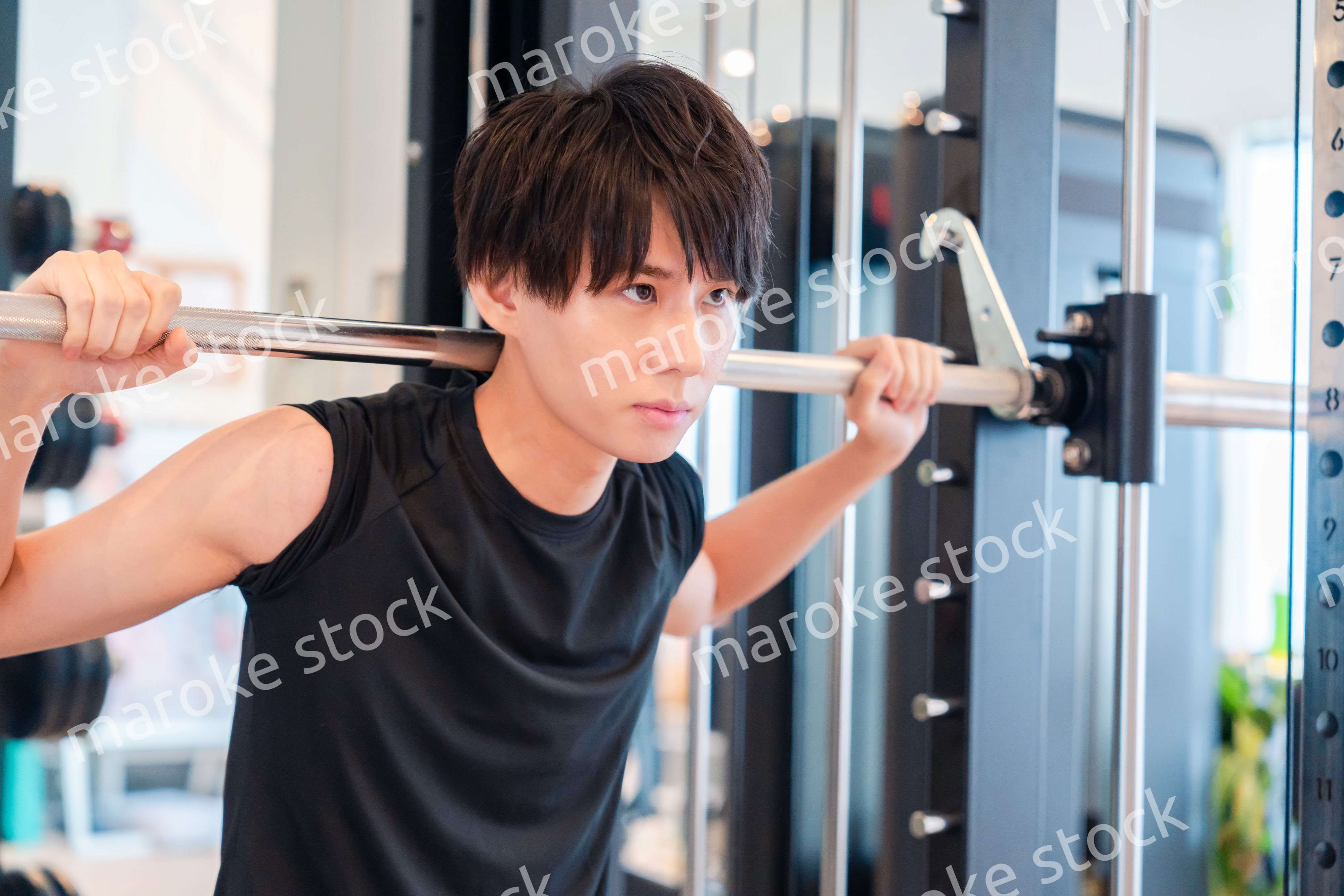 ジムで筋トレをする若い男性