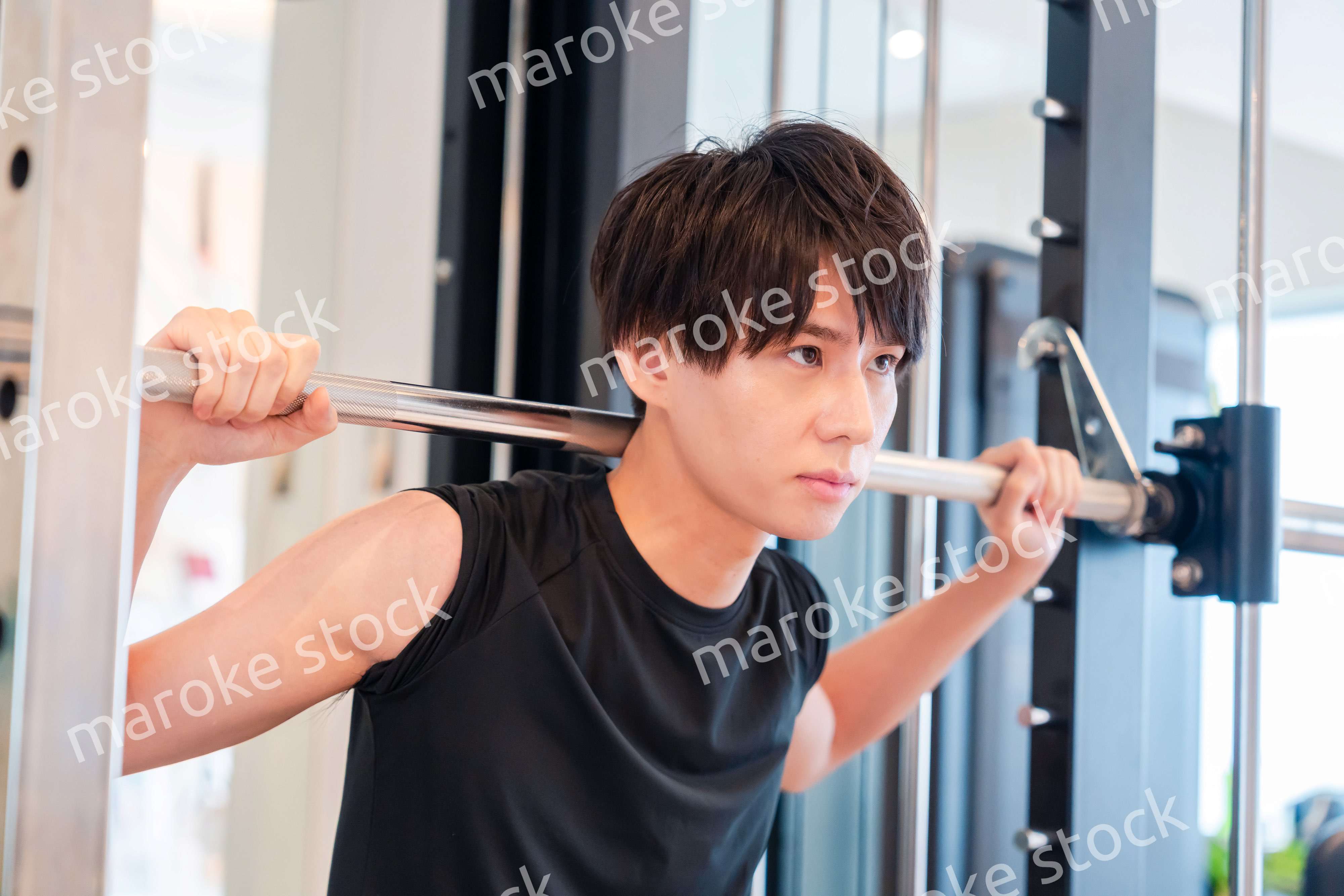 ジムで筋トレをする若い男性