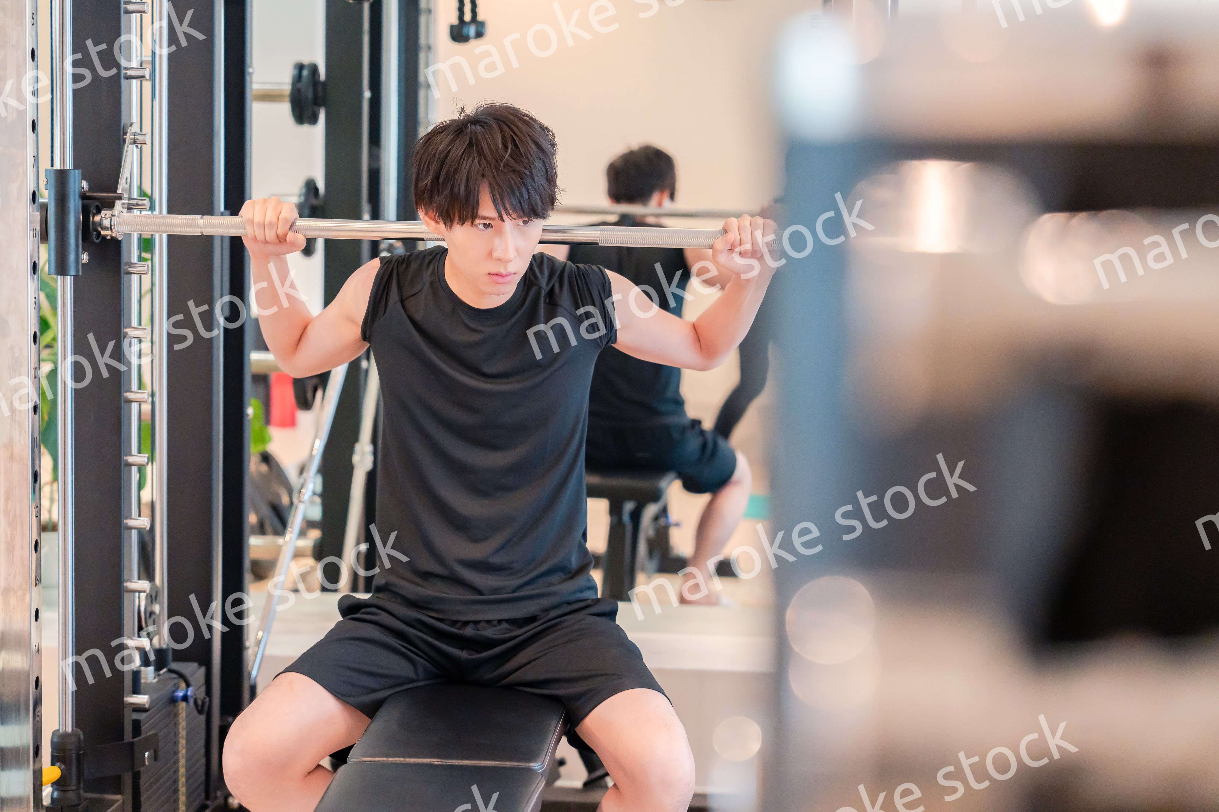 ジムで筋トレをする若い男性