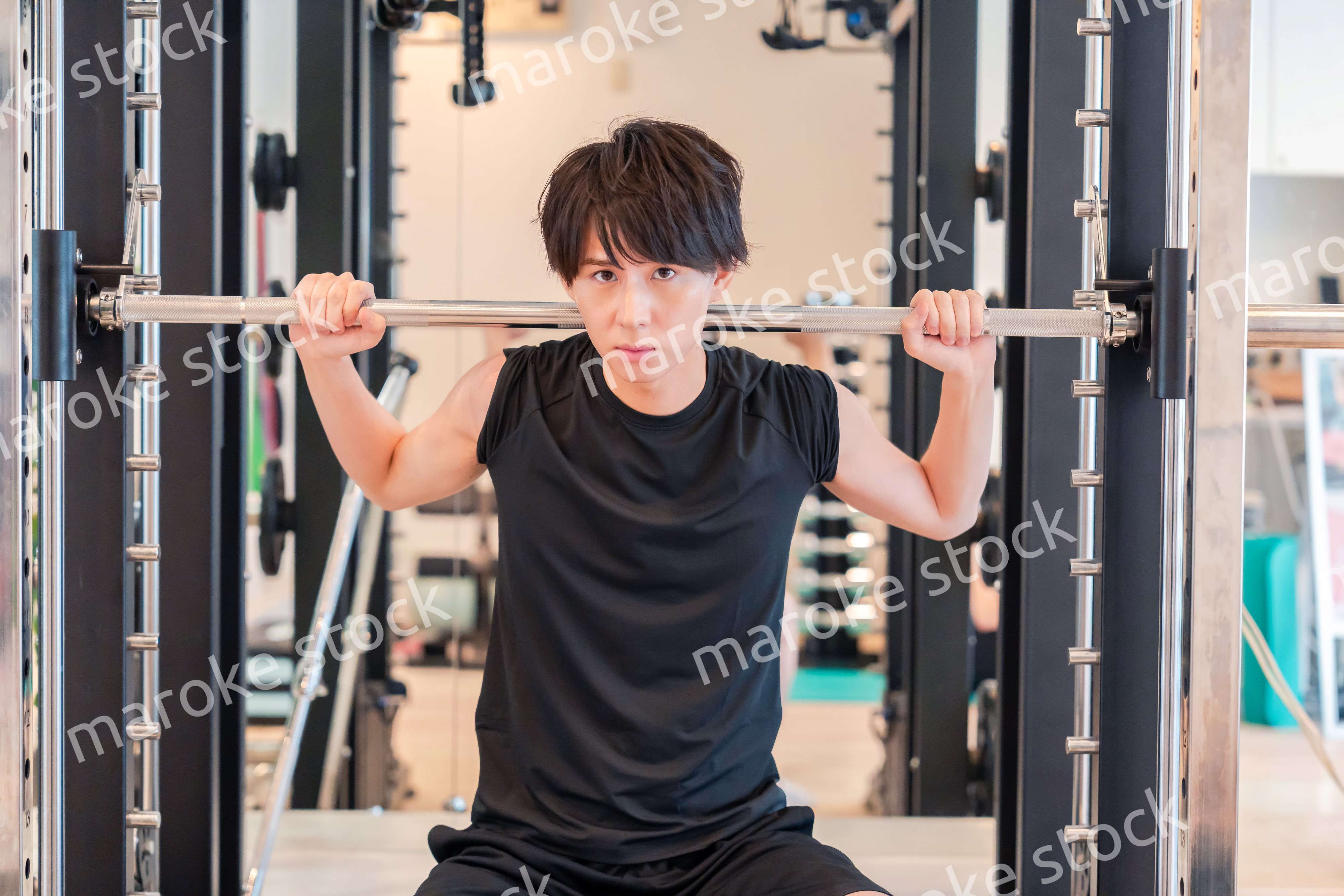 ジムで筋トレをする若い男性