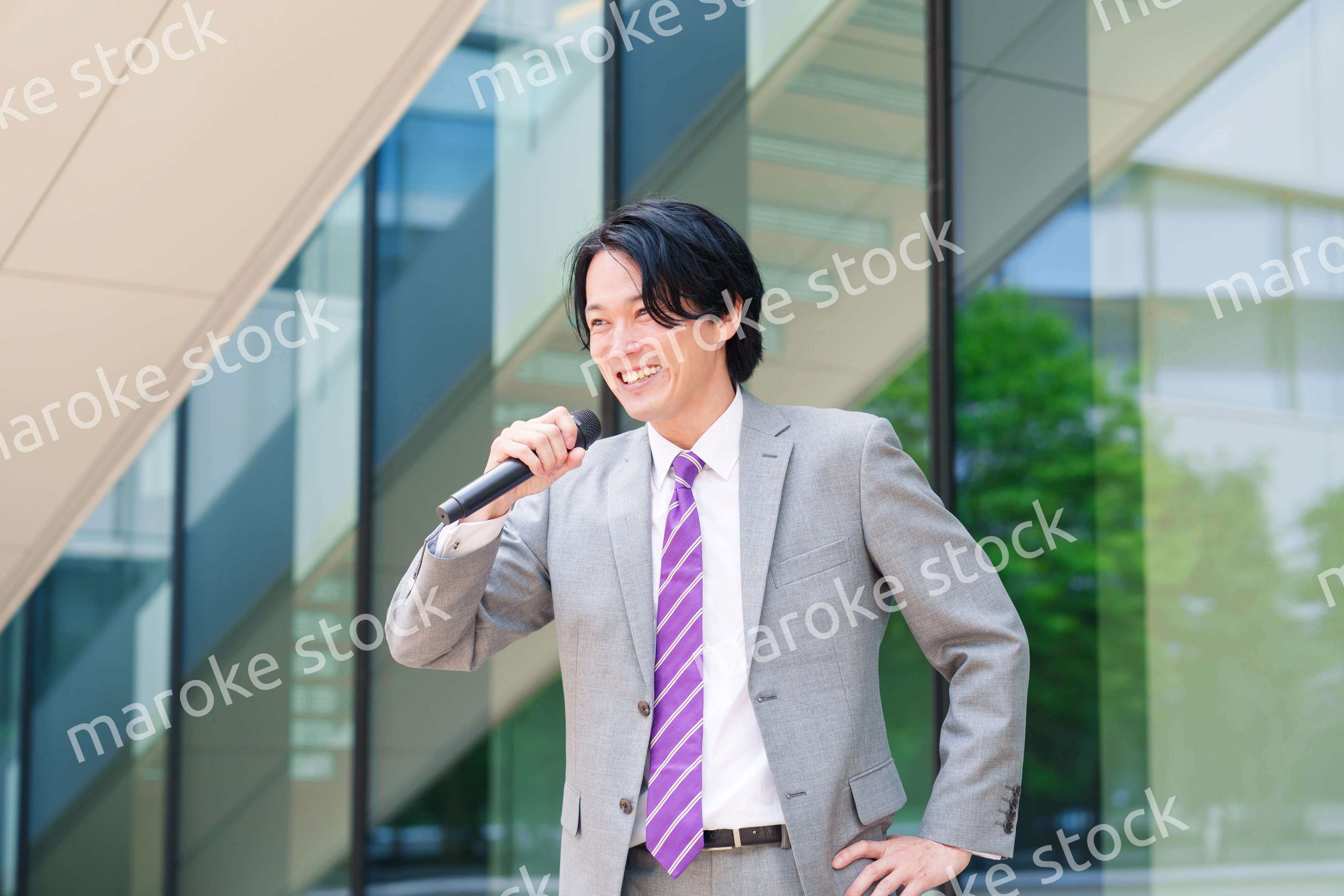 マイクを使って街なかで演説をするスーツを着た男性