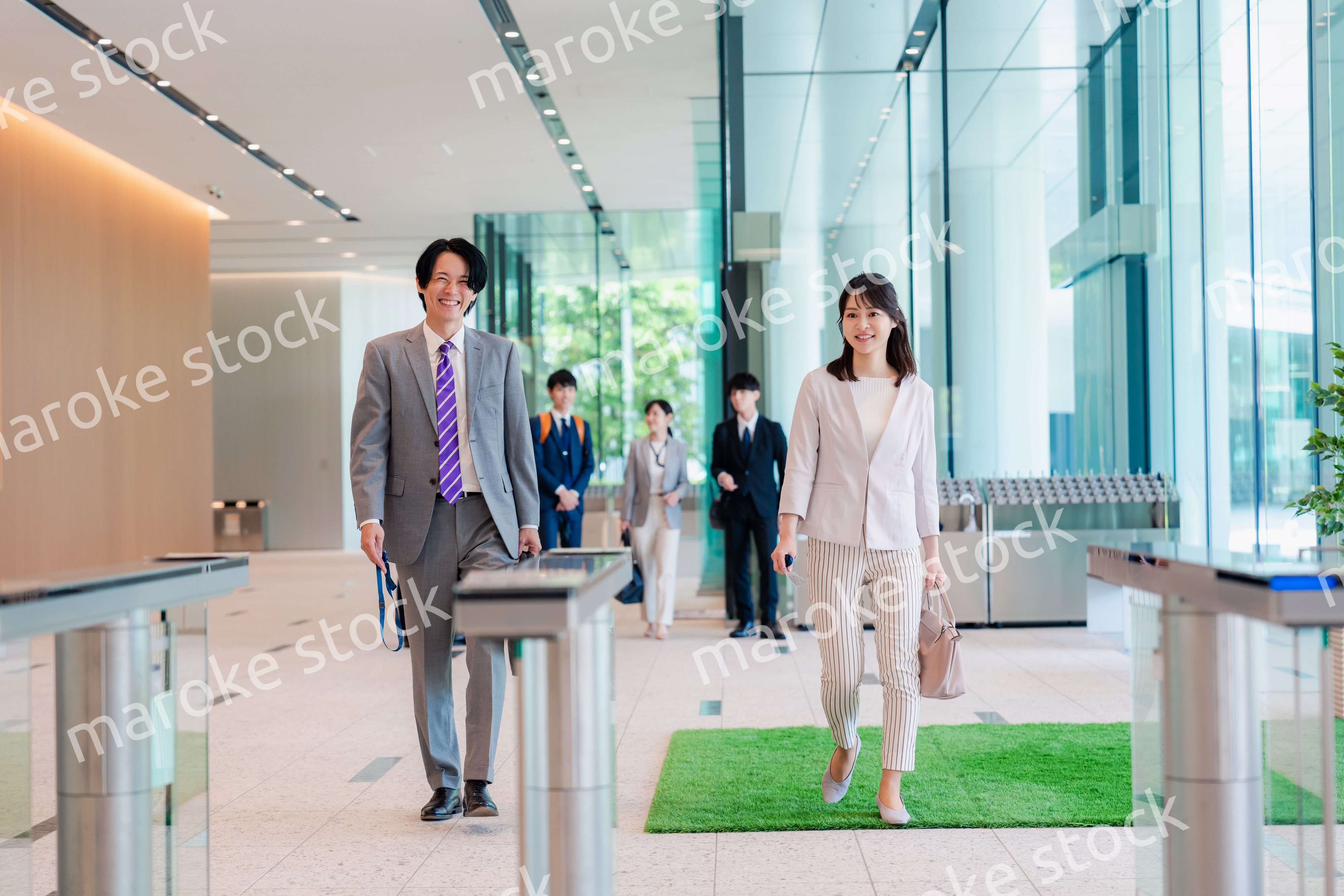 オフィスのエントランスを通るビジネスパーソン