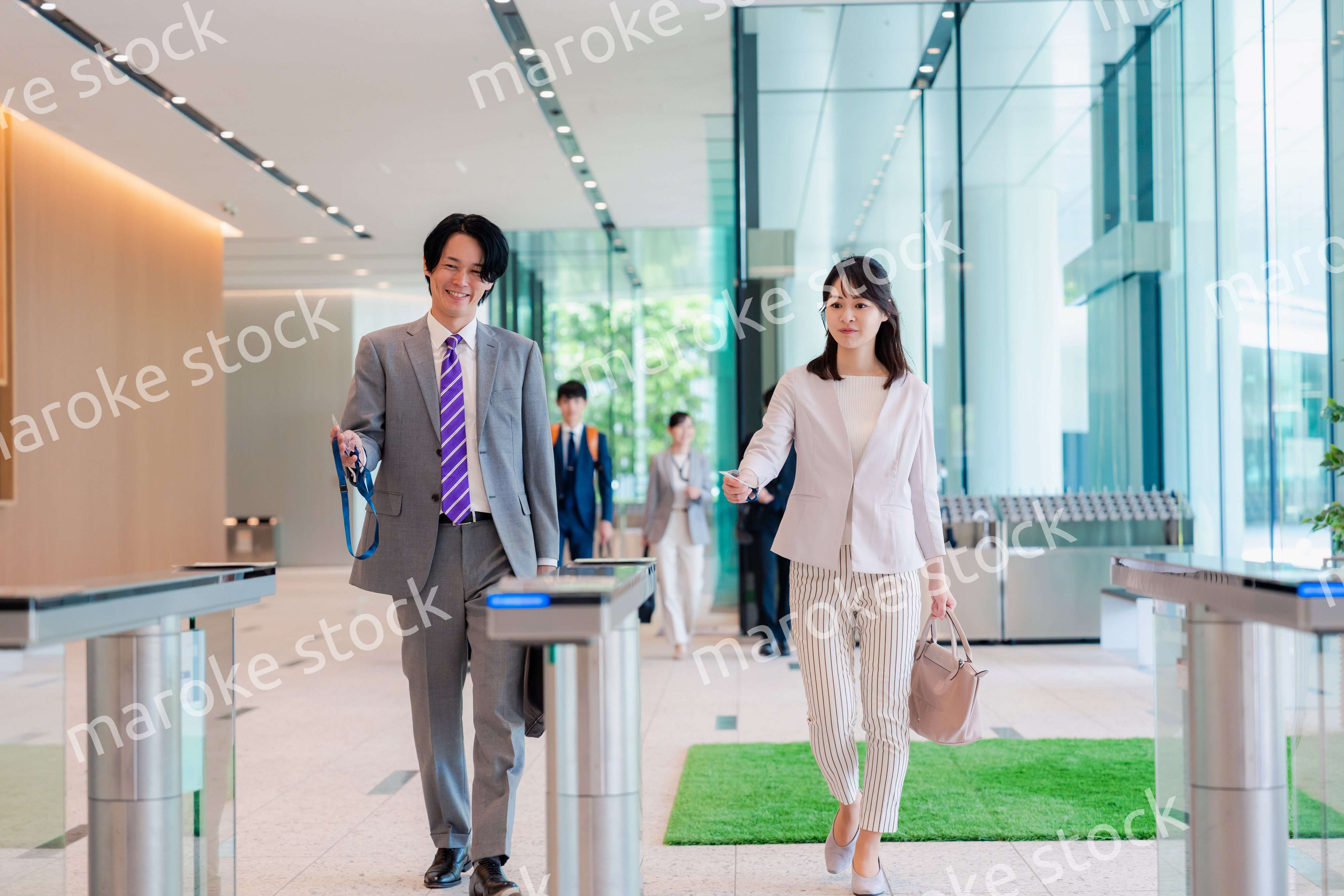 オフィスのエントランスを通るビジネスパーソン