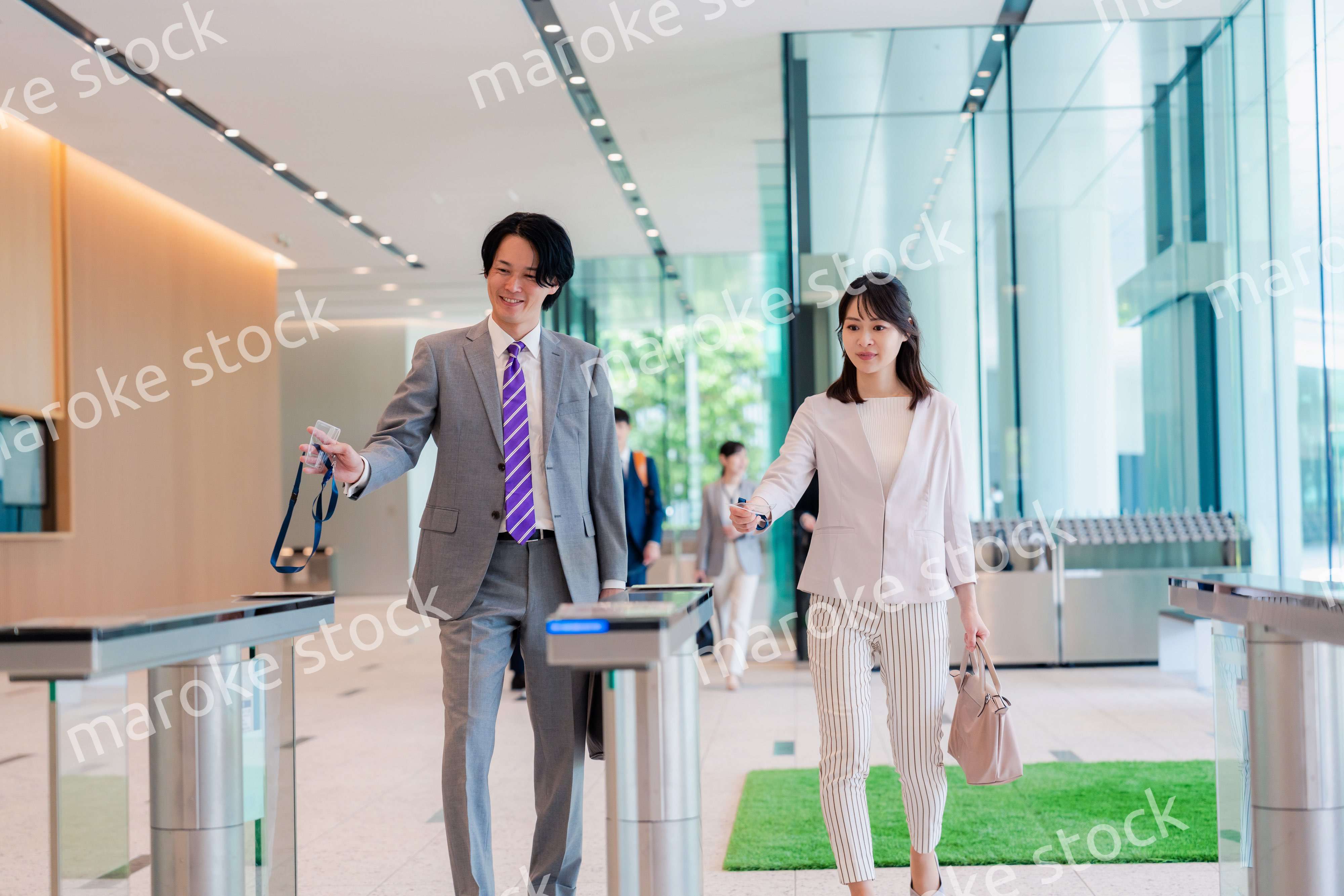 オフィスのエントランスを通るビジネスパーソン