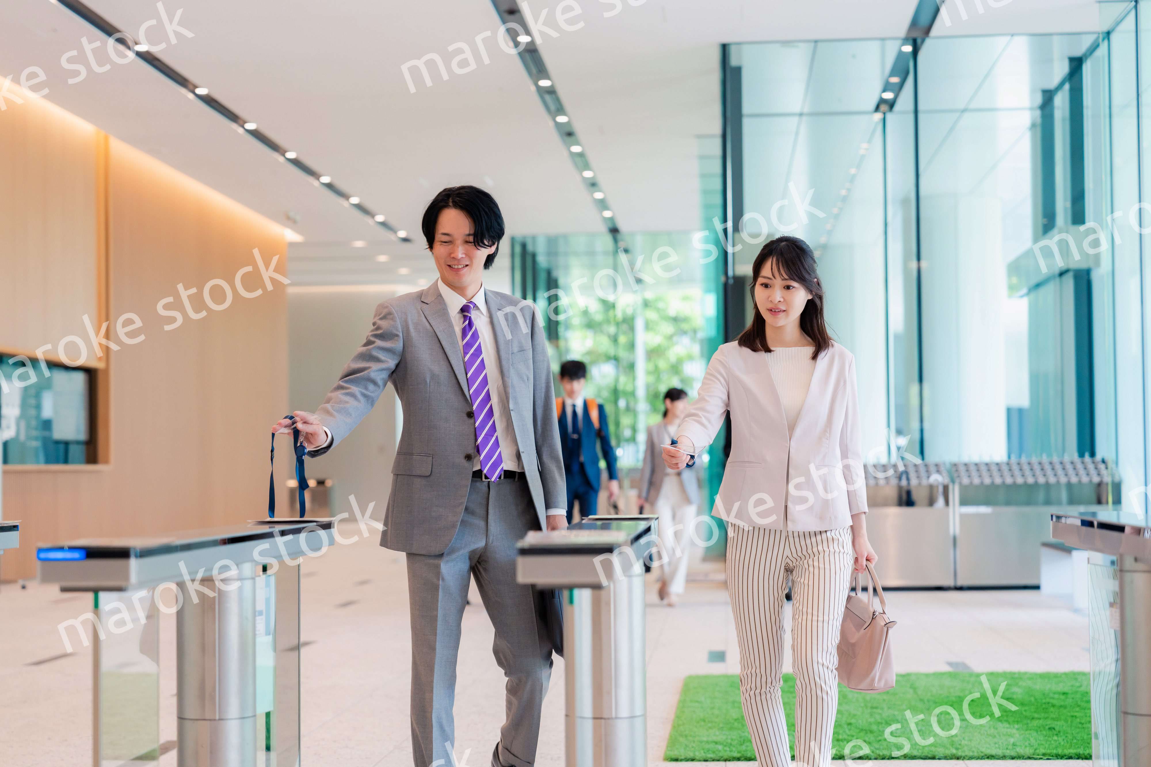 オフィスのエントランスを通るビジネスパーソン