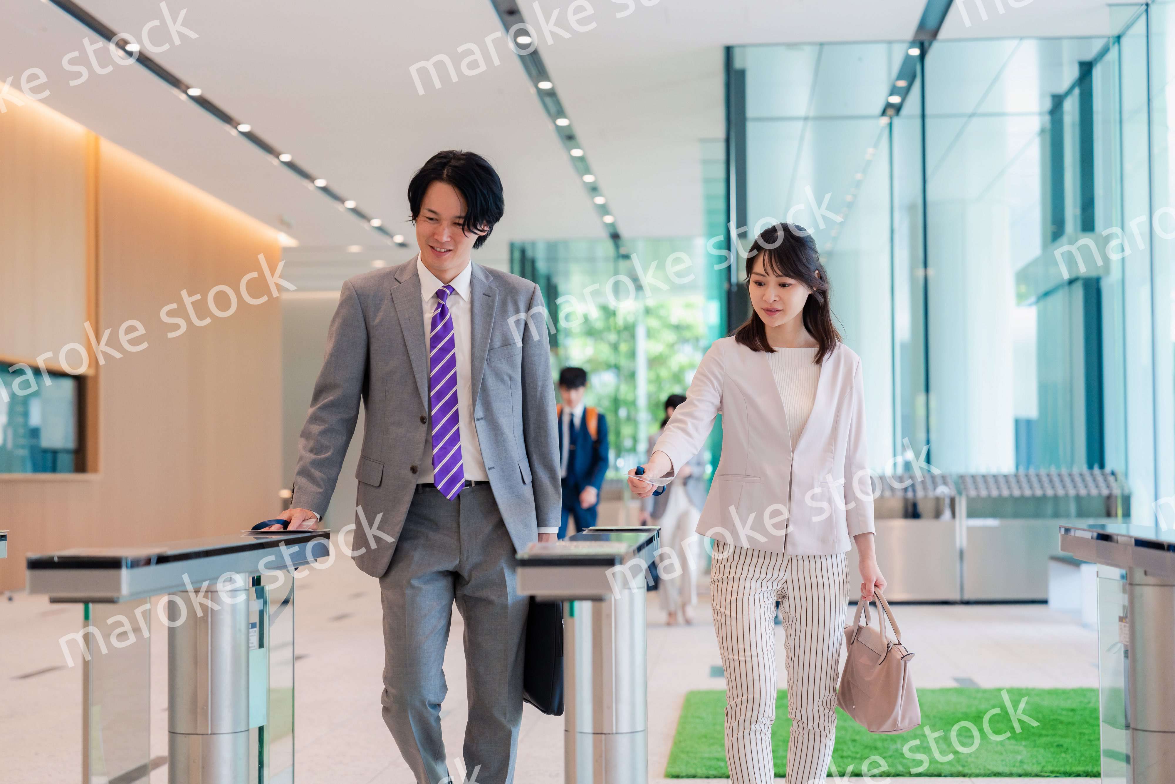 オフィスのエントランスを通るビジネスパーソン