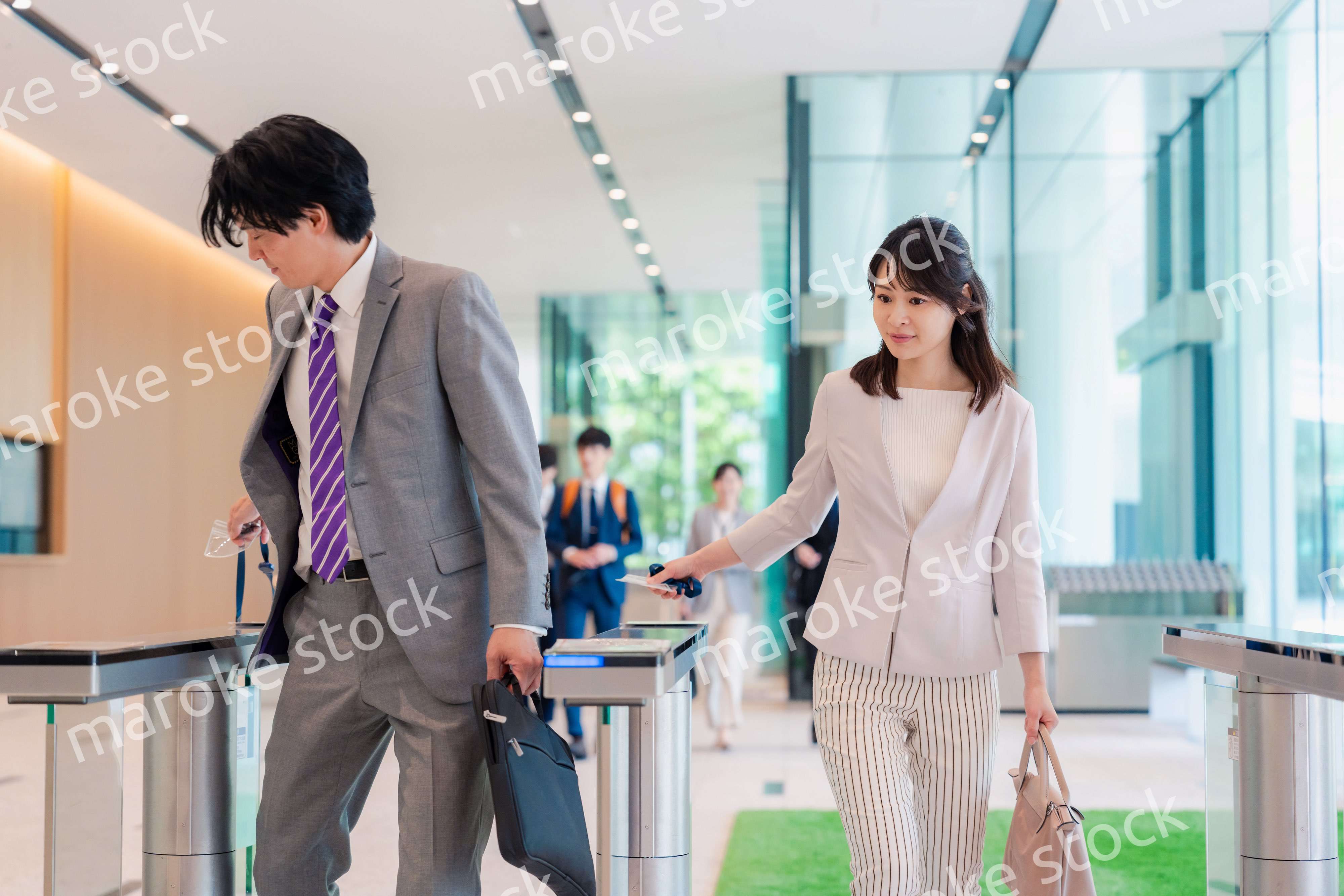 オフィスのエントランスを通るビジネスパーソン