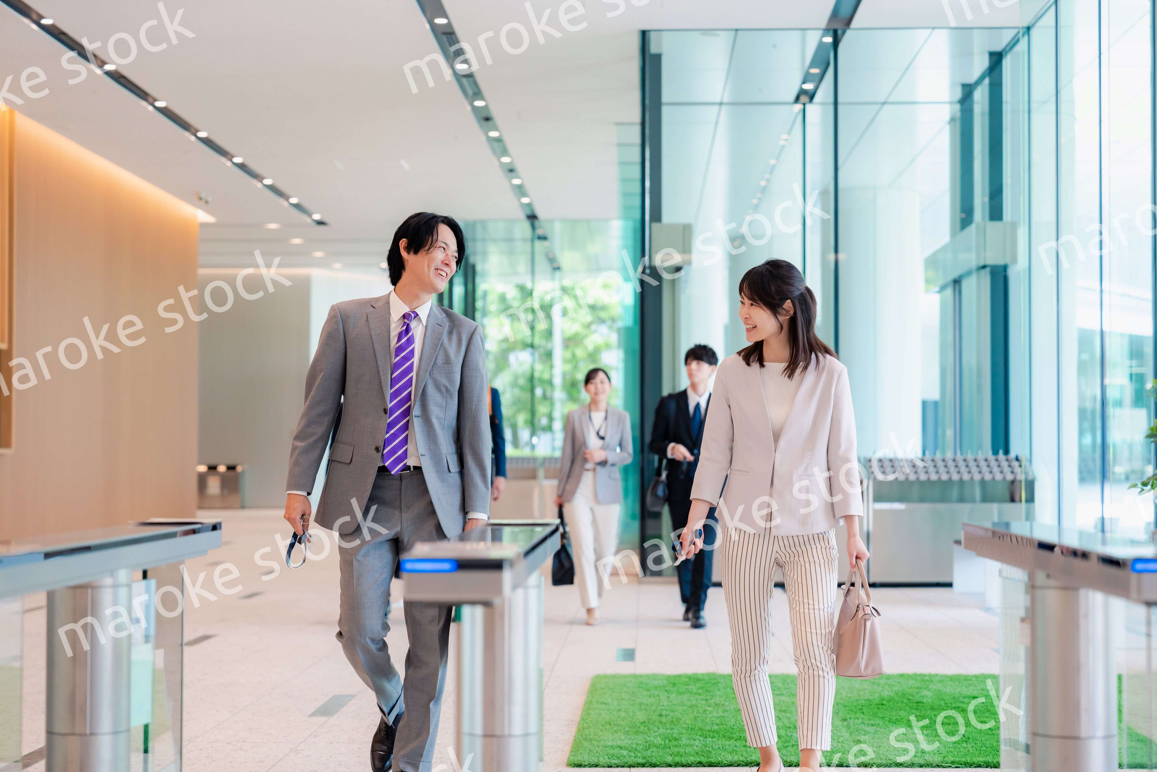 オフィスのエントランスを通るビジネスパーソン