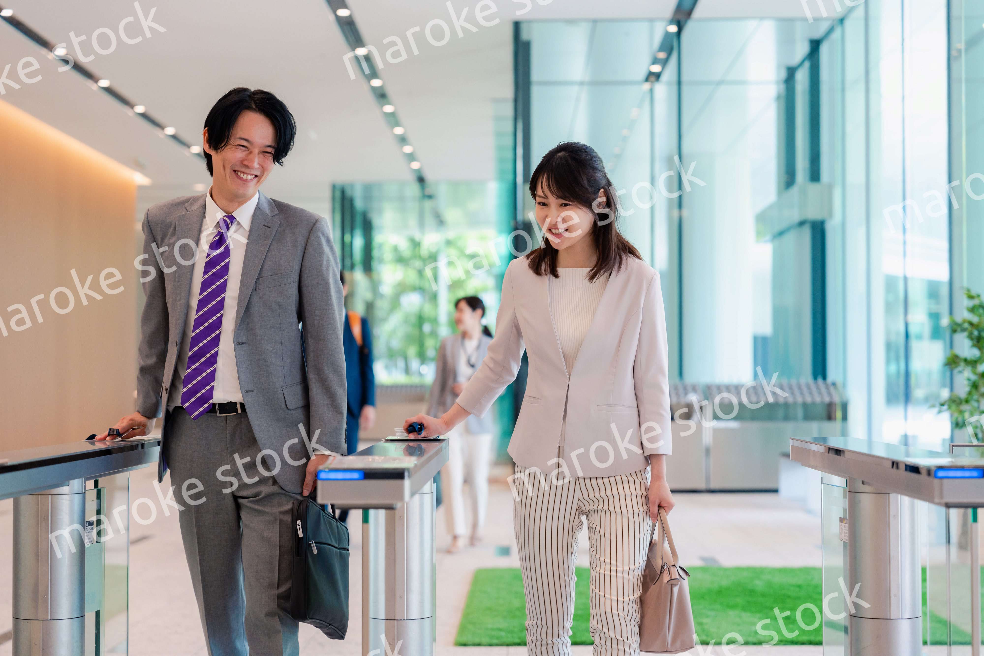 オフィスのエントランスを通るビジネスパーソン