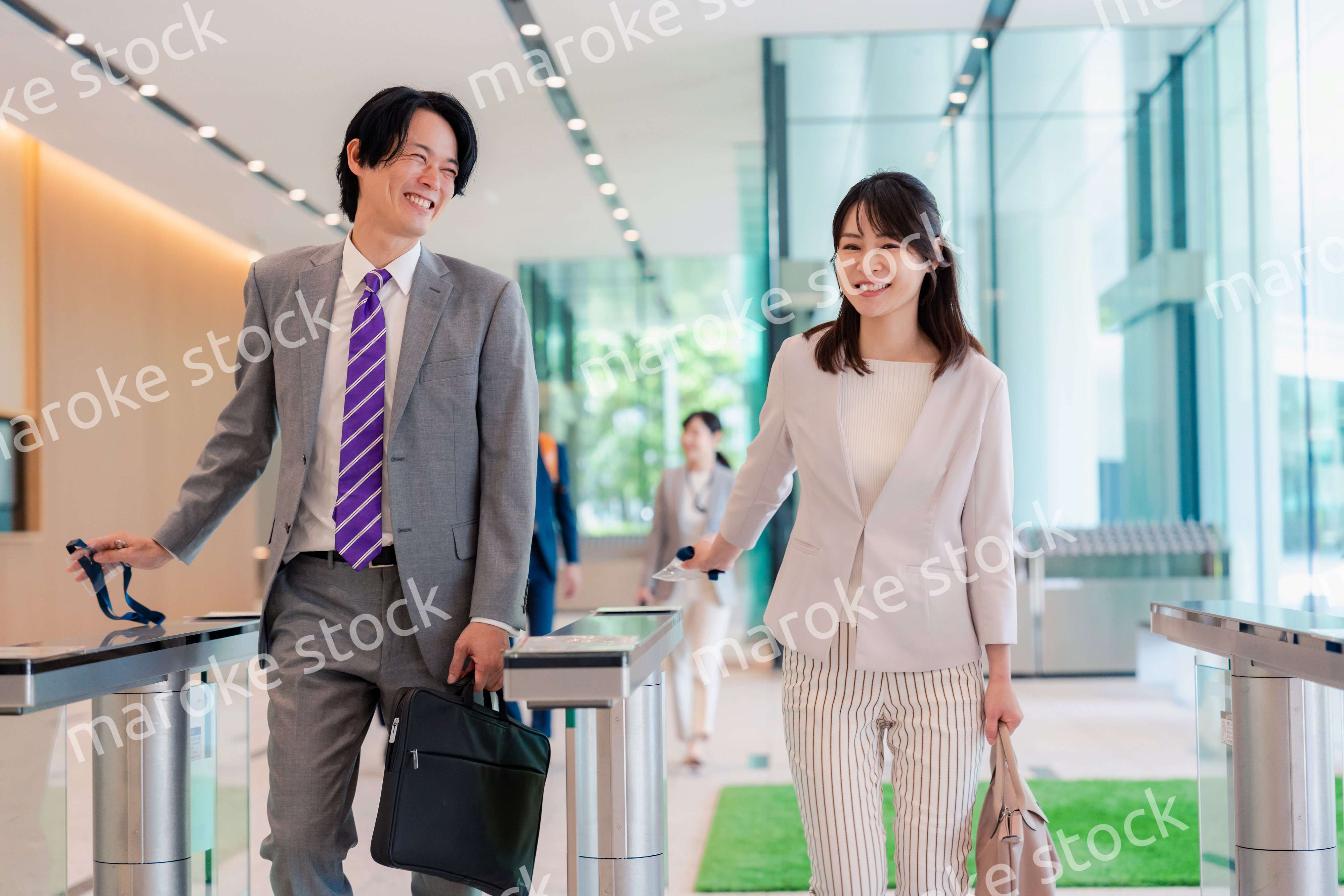 オフィスのエントランスを通るビジネスパーソン
