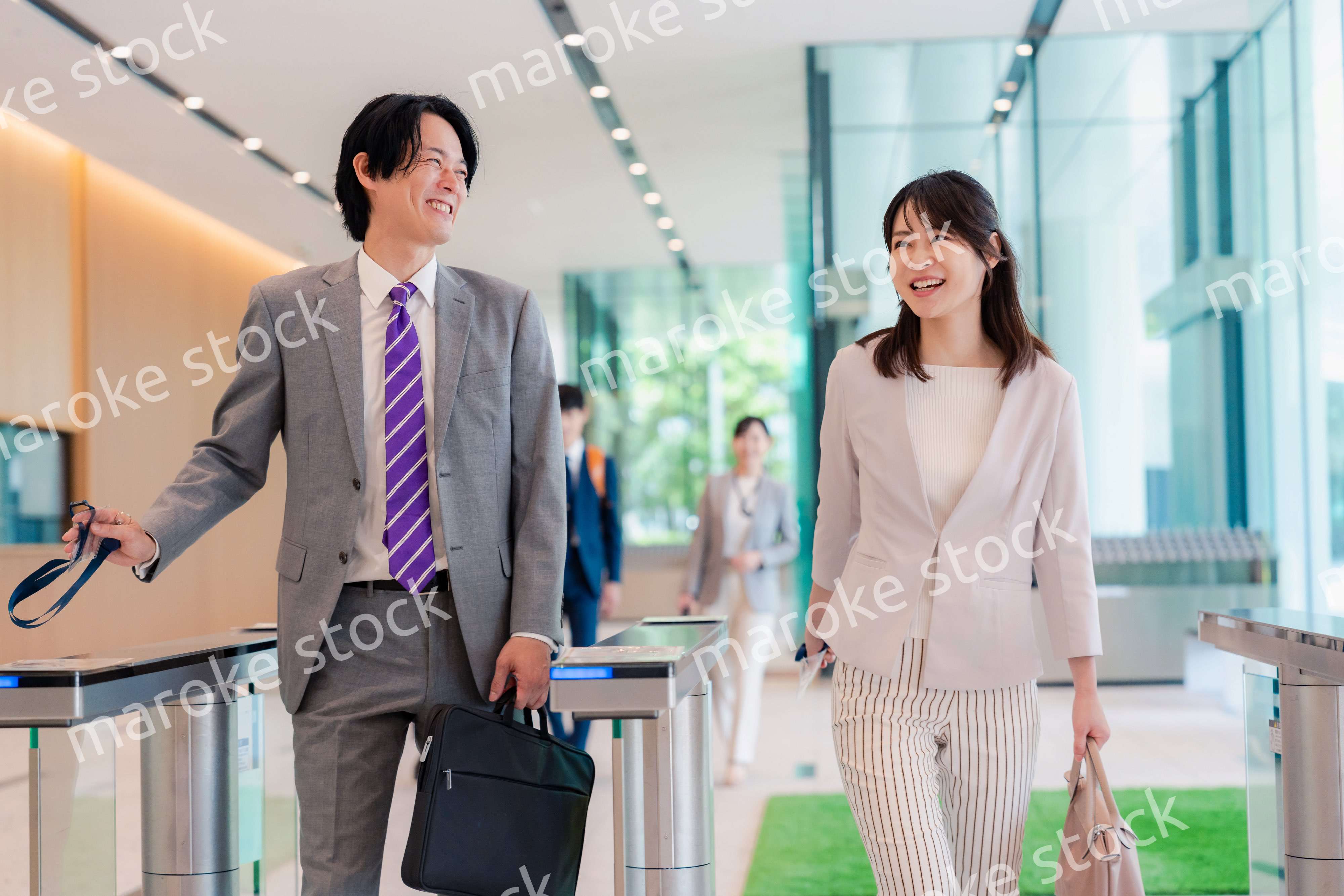 オフィスのエントランスを通るビジネスパーソン