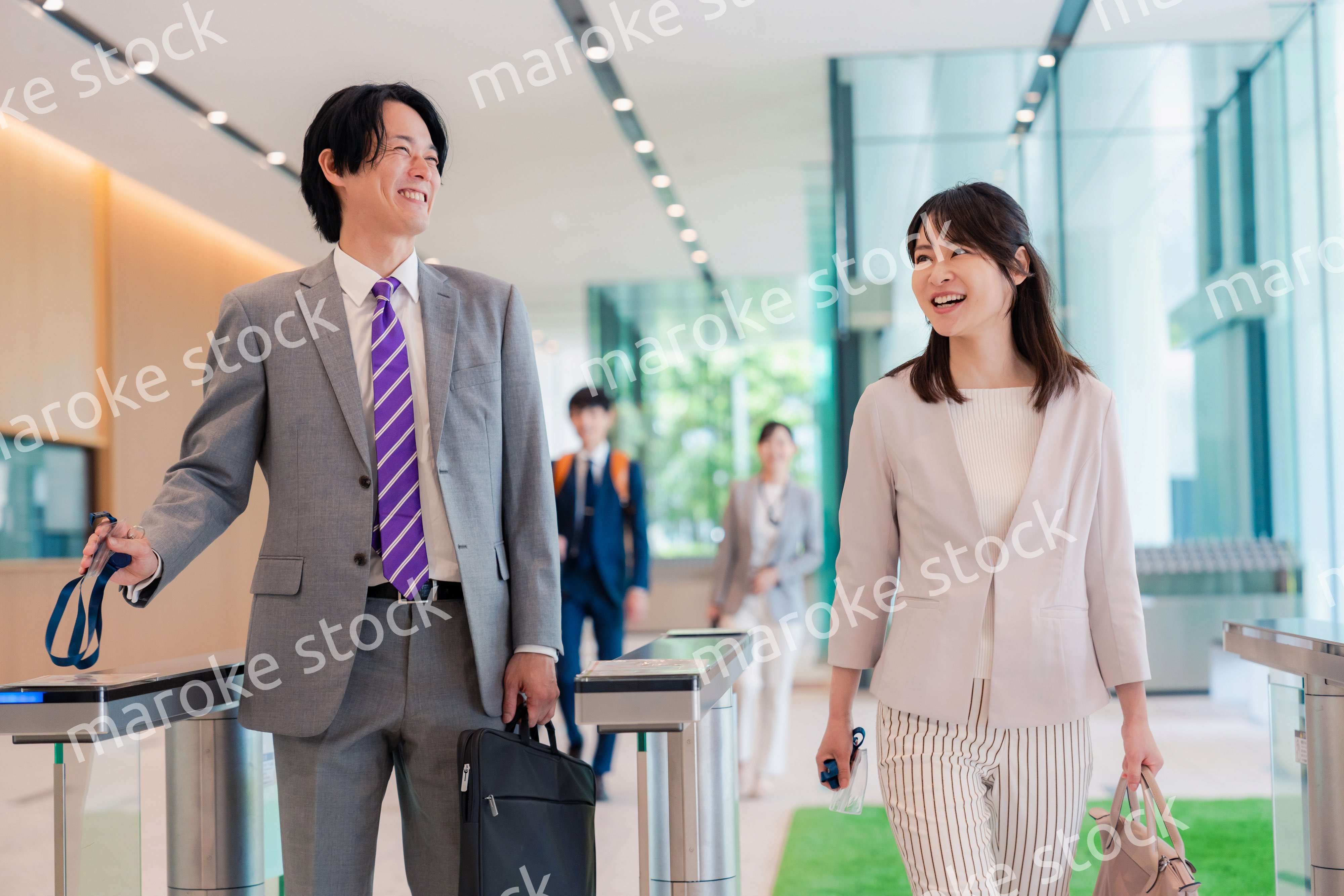 オフィスのエントランスを通るビジネスパーソン