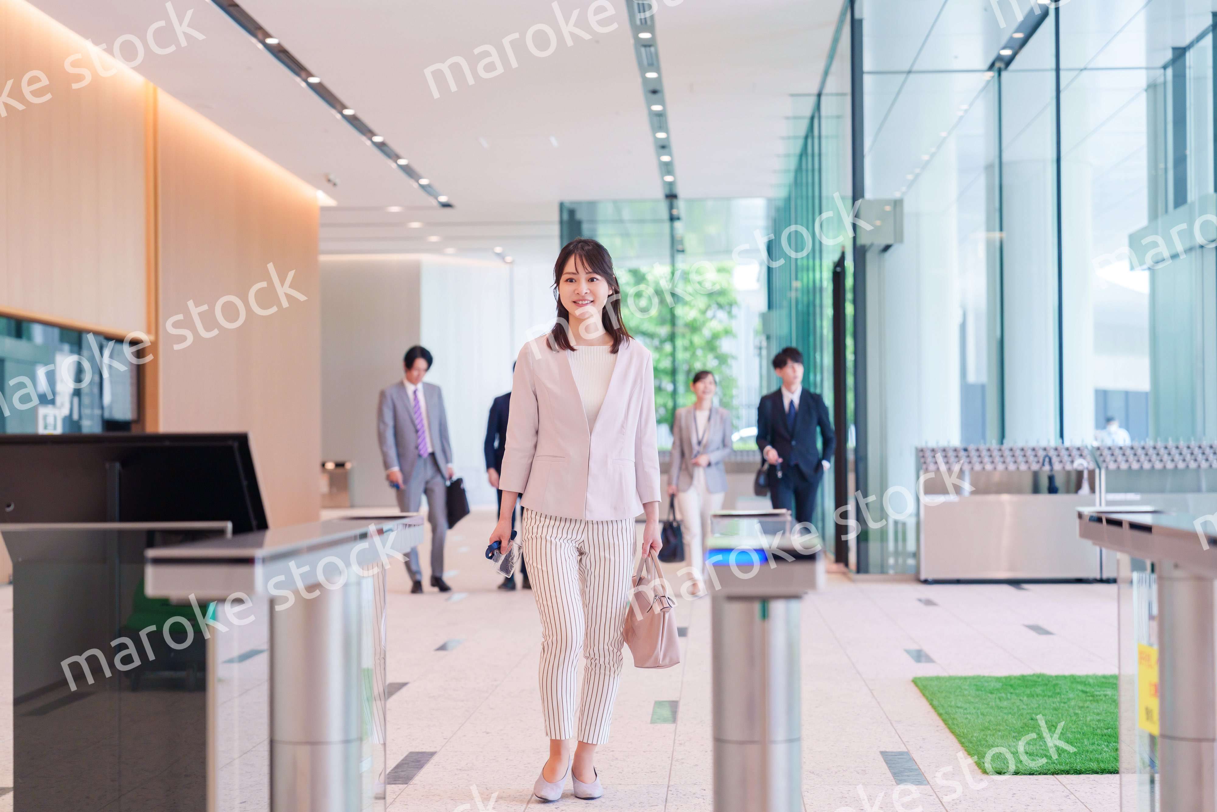 オフィスのセキュリティゲートを通るビジネスウーマン