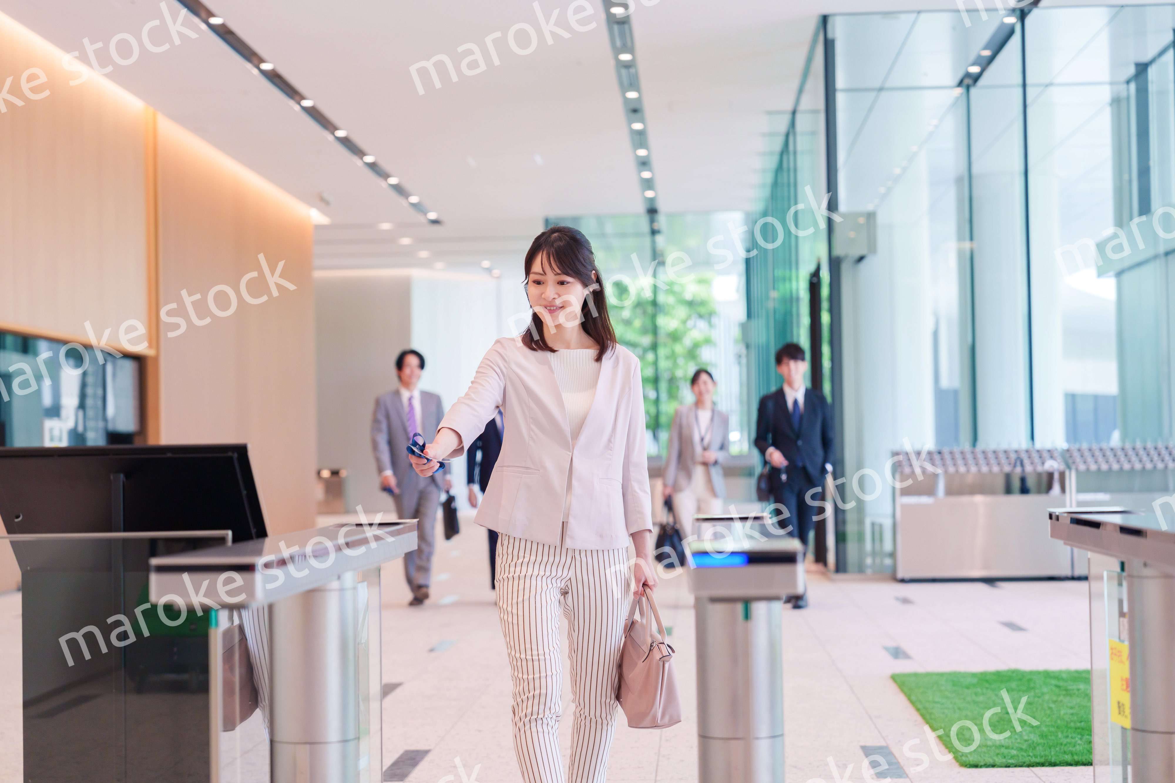 オフィスのセキュリティゲートを通るビジネスウーマン