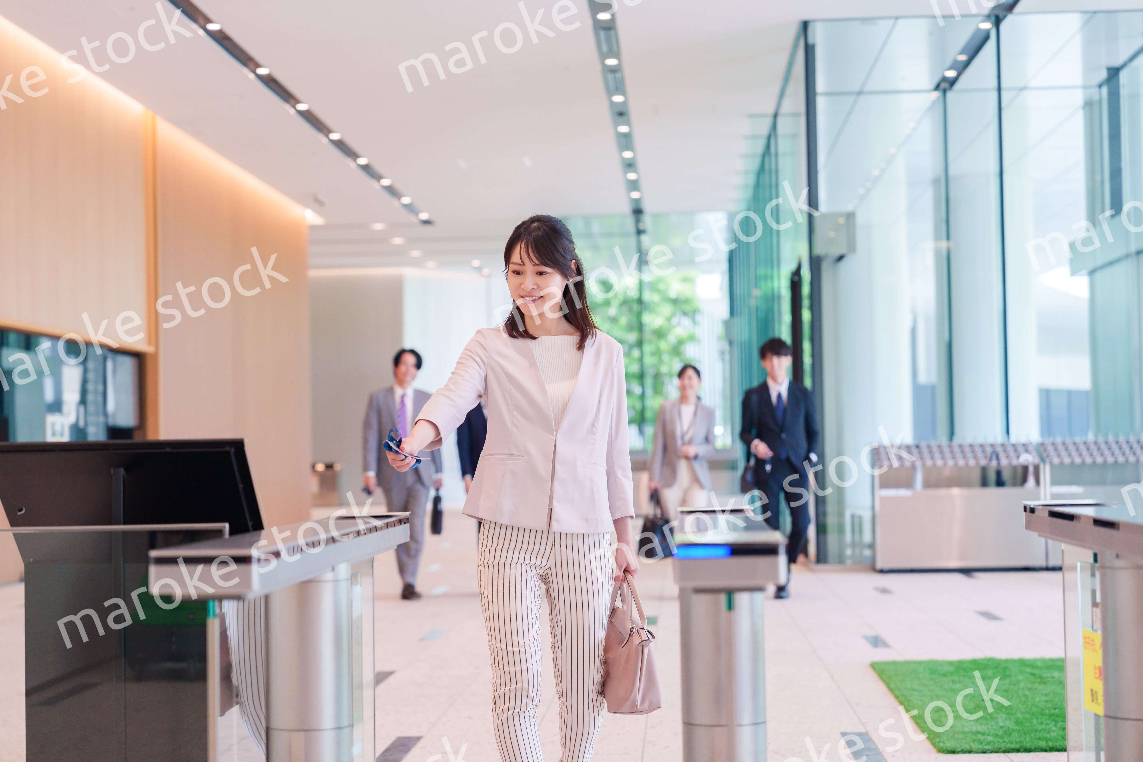 オフィスのセキュリティゲートを通るビジネスウーマン