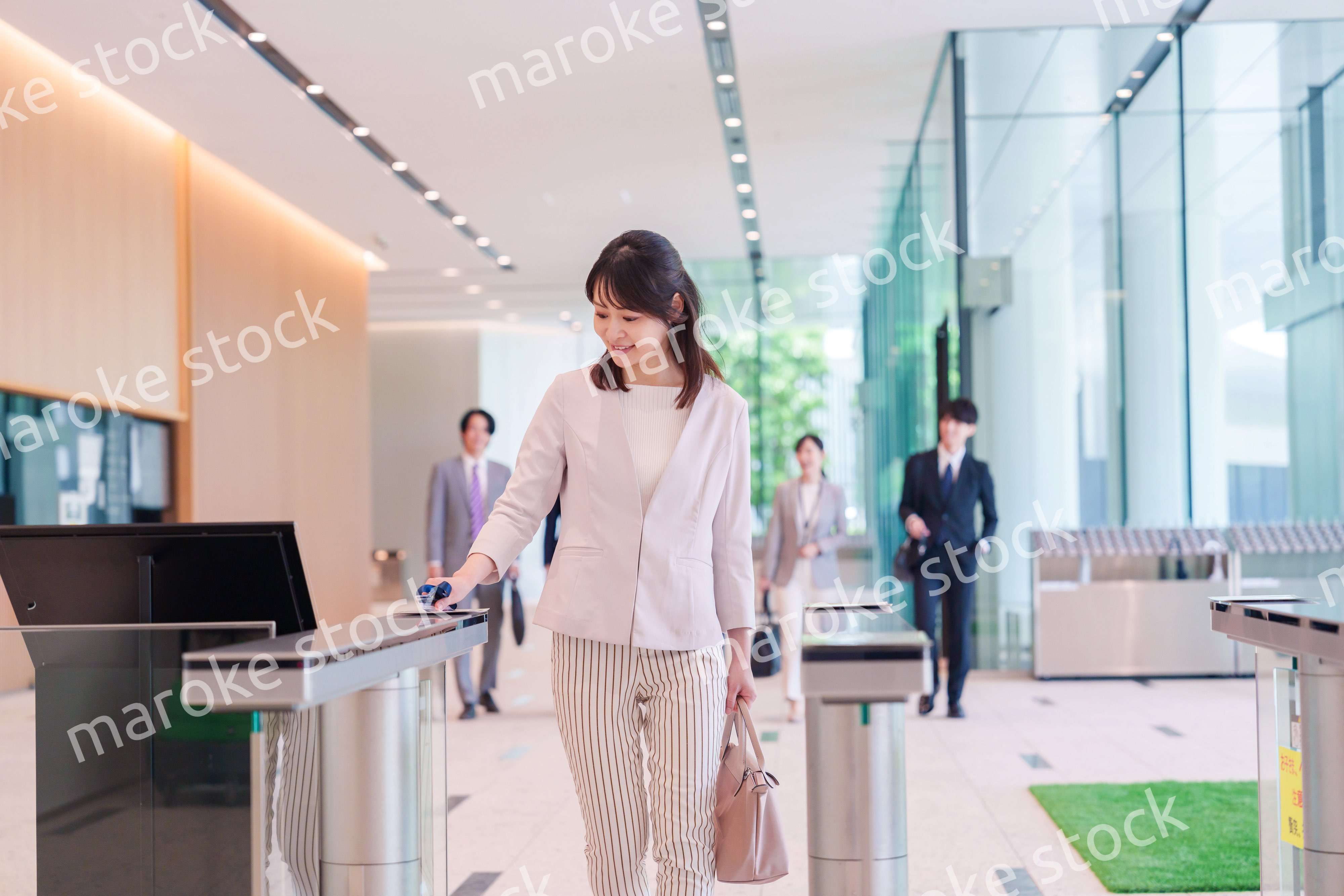 オフィスのセキュリティゲートを通るビジネスウーマン