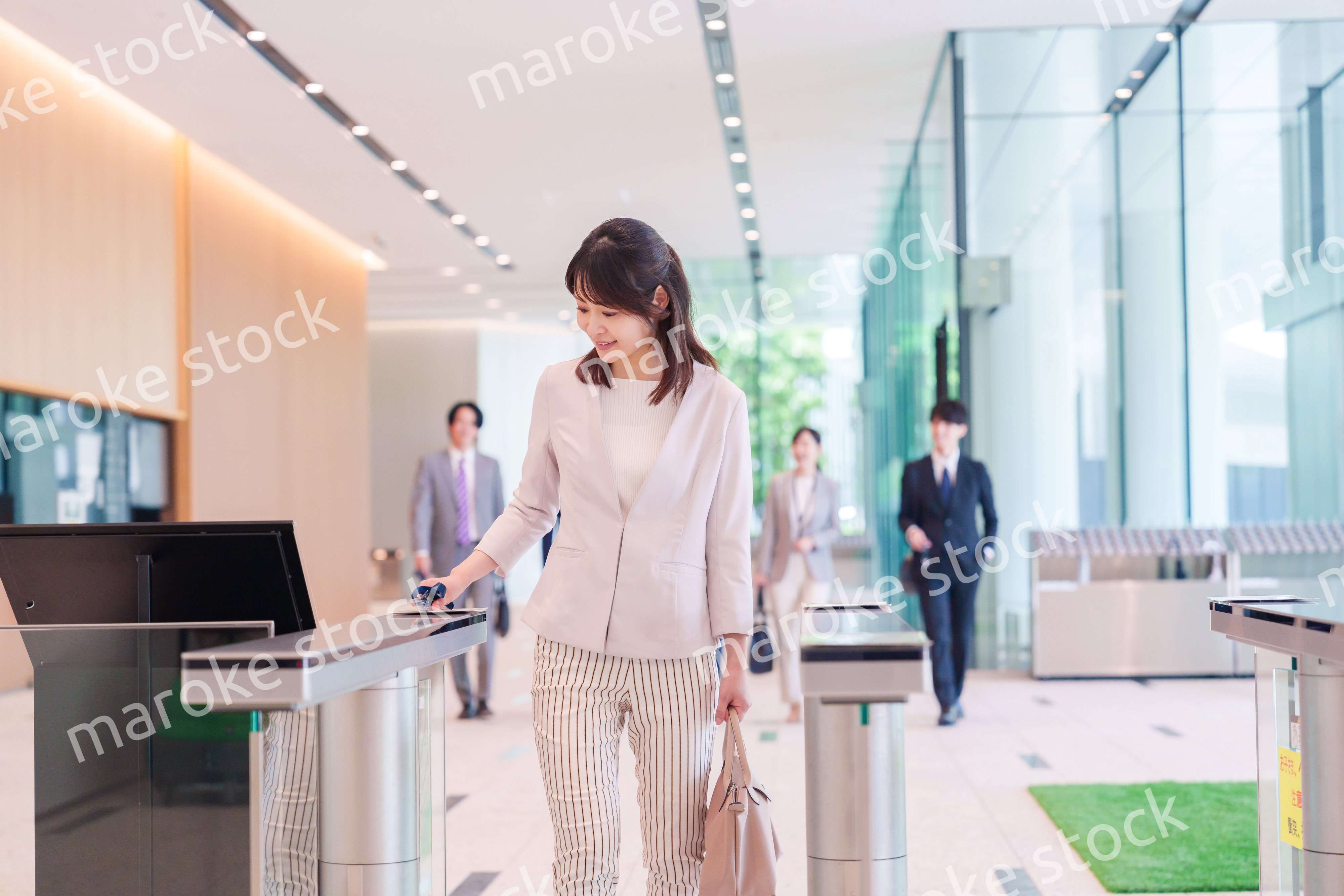 オフィスのセキュリティゲートを通るビジネスウーマン