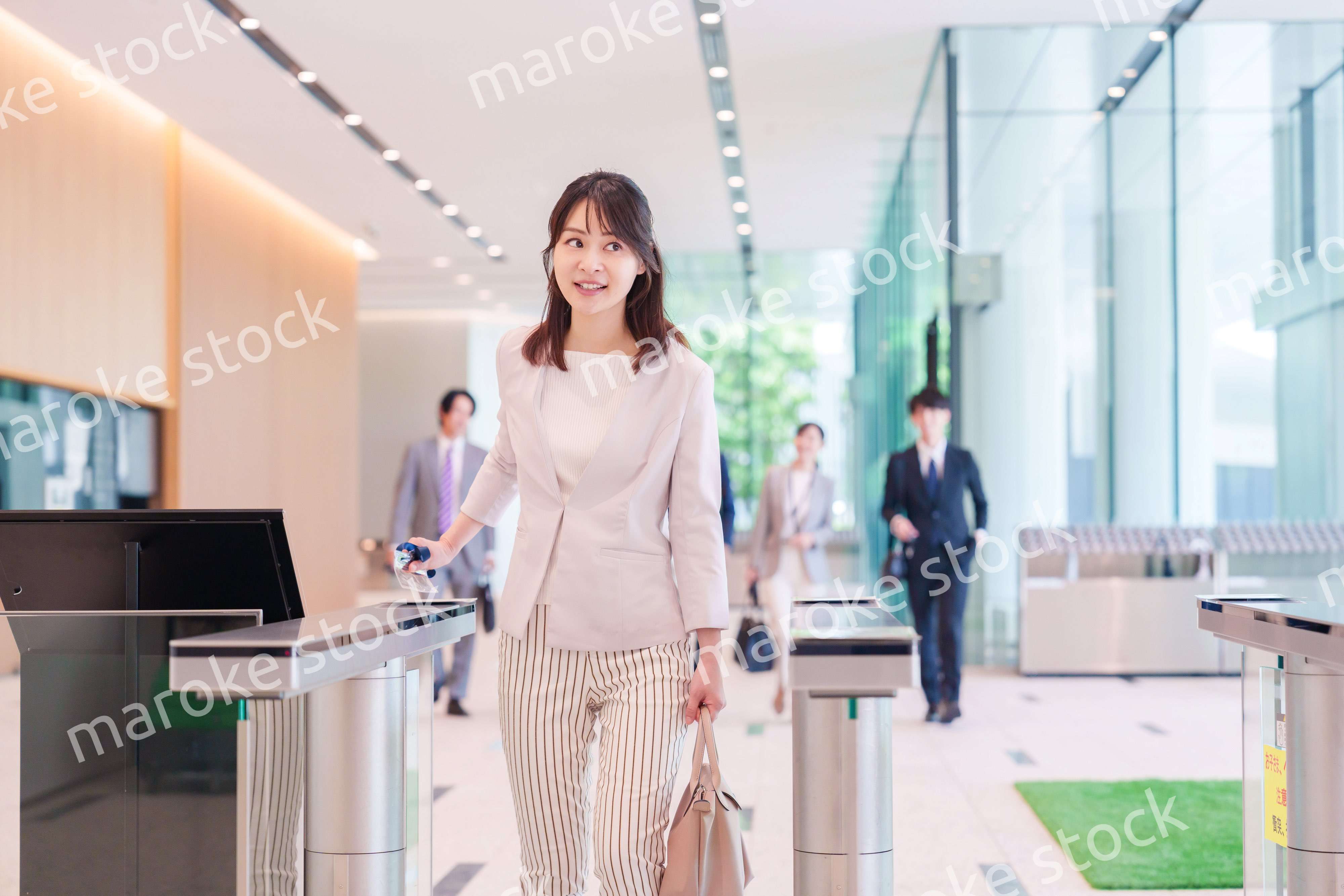 オフィスのセキュリティゲートを通るビジネスウーマン